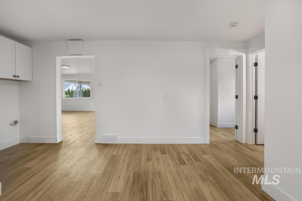 Unfurnished room featuring light wood-type flooring and baseboards