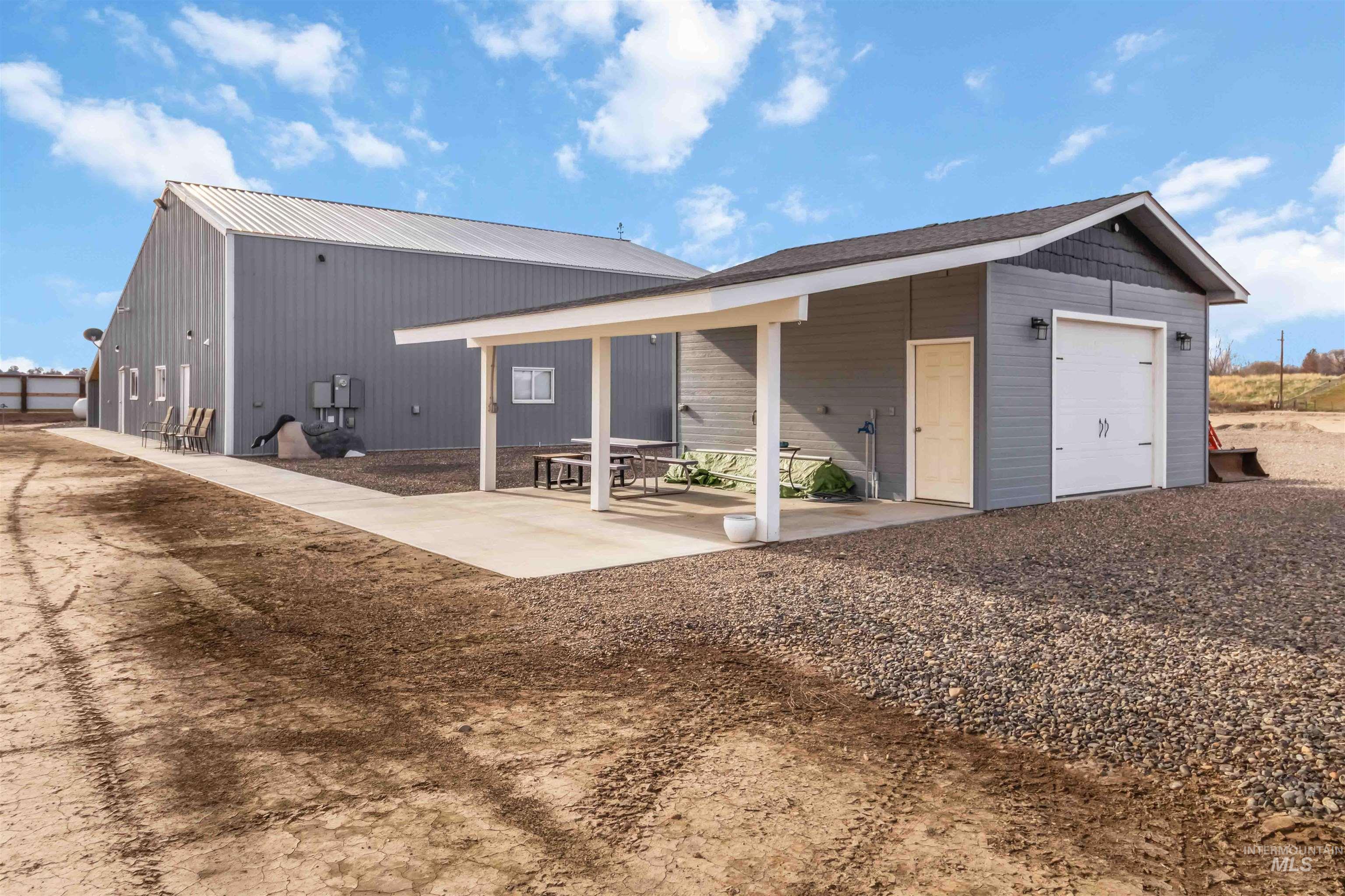 Back of house with an outbuilding and a metal roof