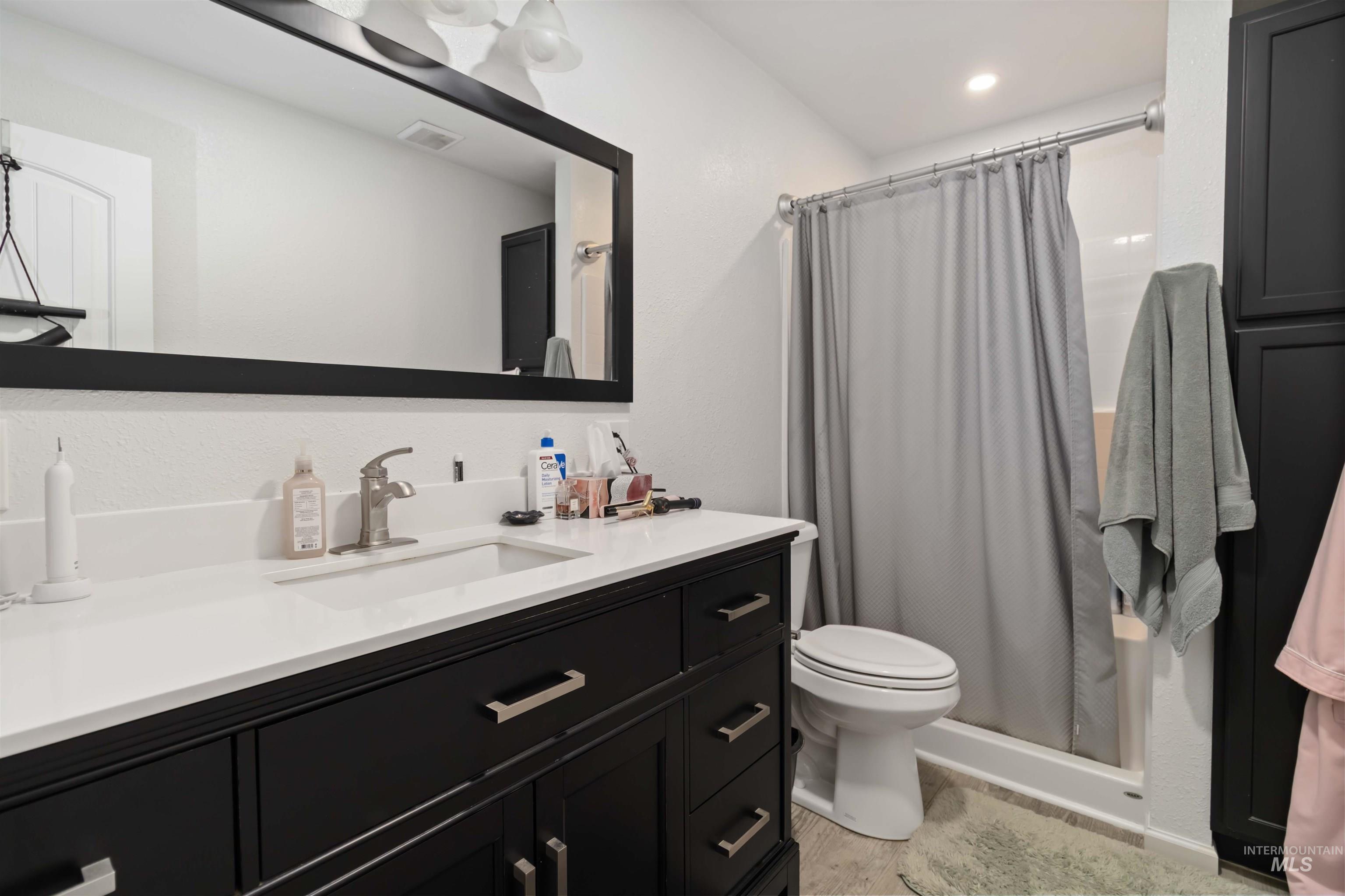 Full bathroom with vanity and a stall shower