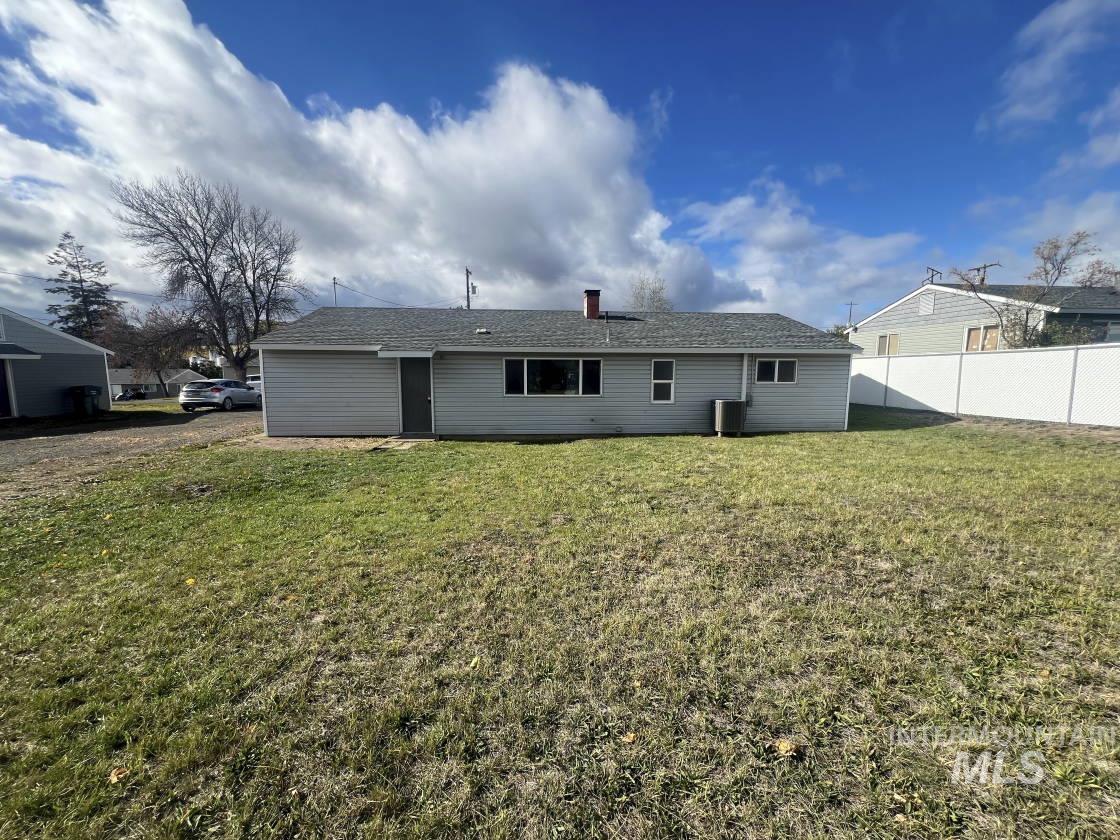 Back of property featuring a chimney and a shingled roof
