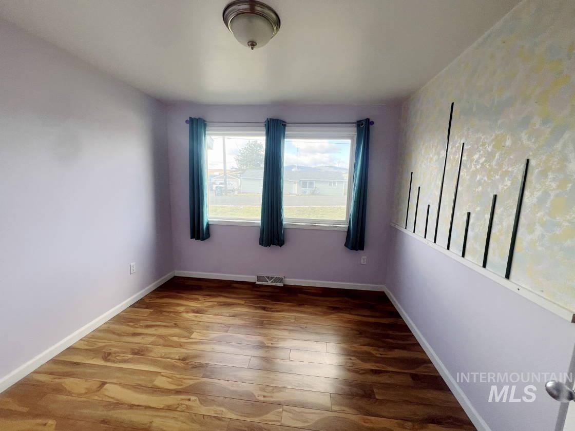 Empty room with wood finished floors and baseboards