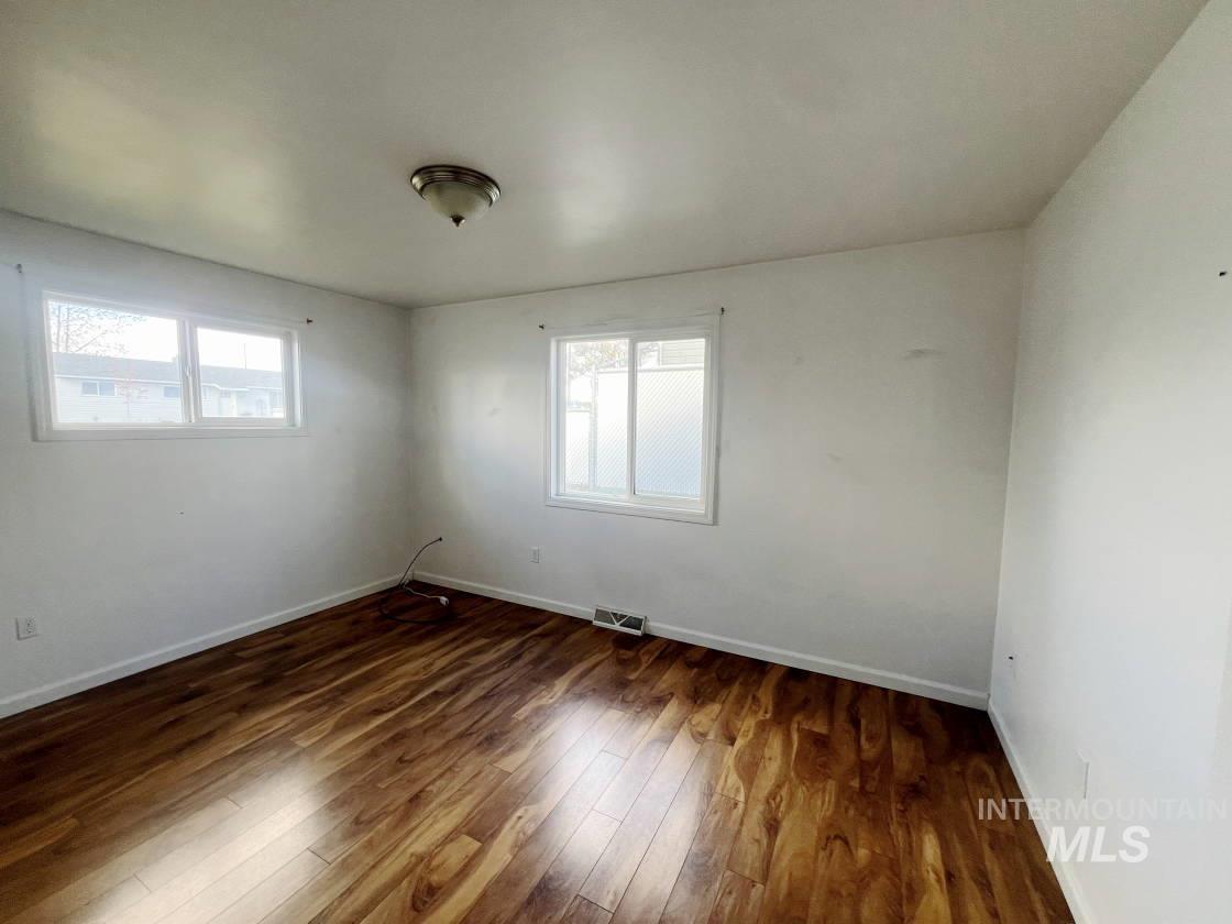 Spare room with dark wood finished floors and healthy amount of natural light