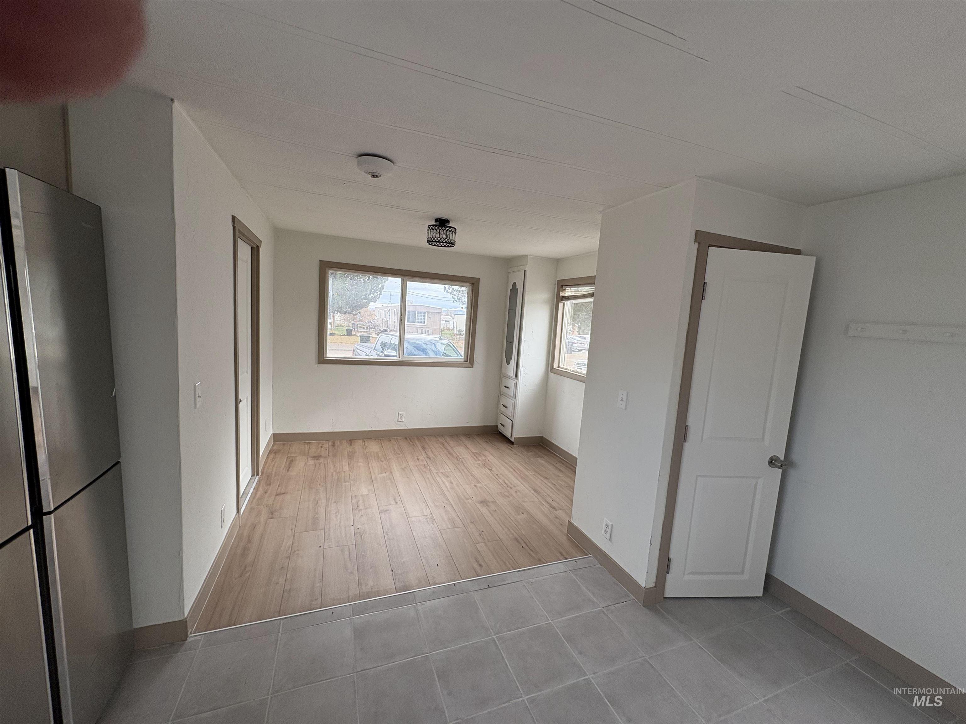 Empty room with baseboards and light tile patterned floors