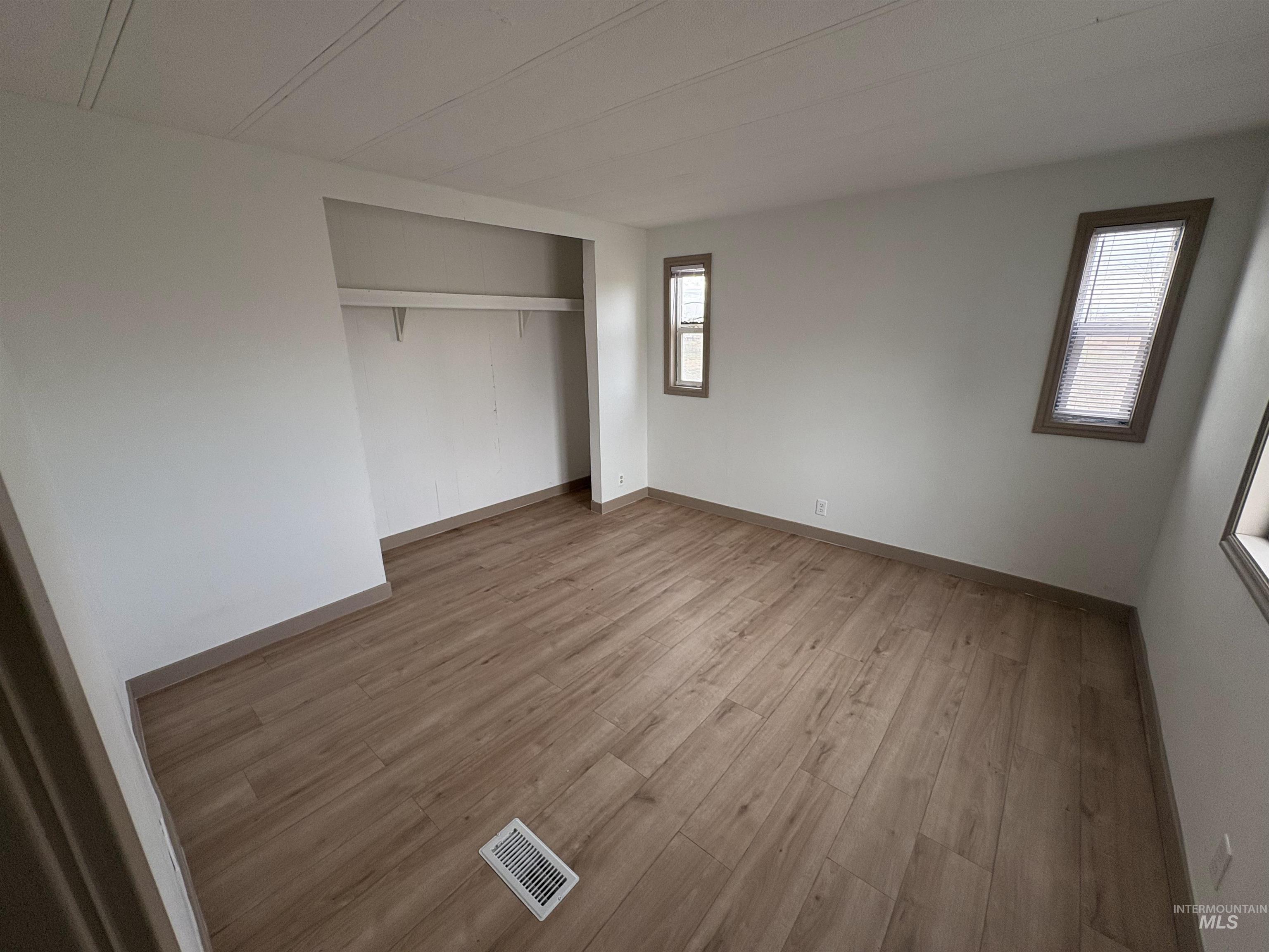 Unfurnished bedroom featuring light wood finished floors and a closet