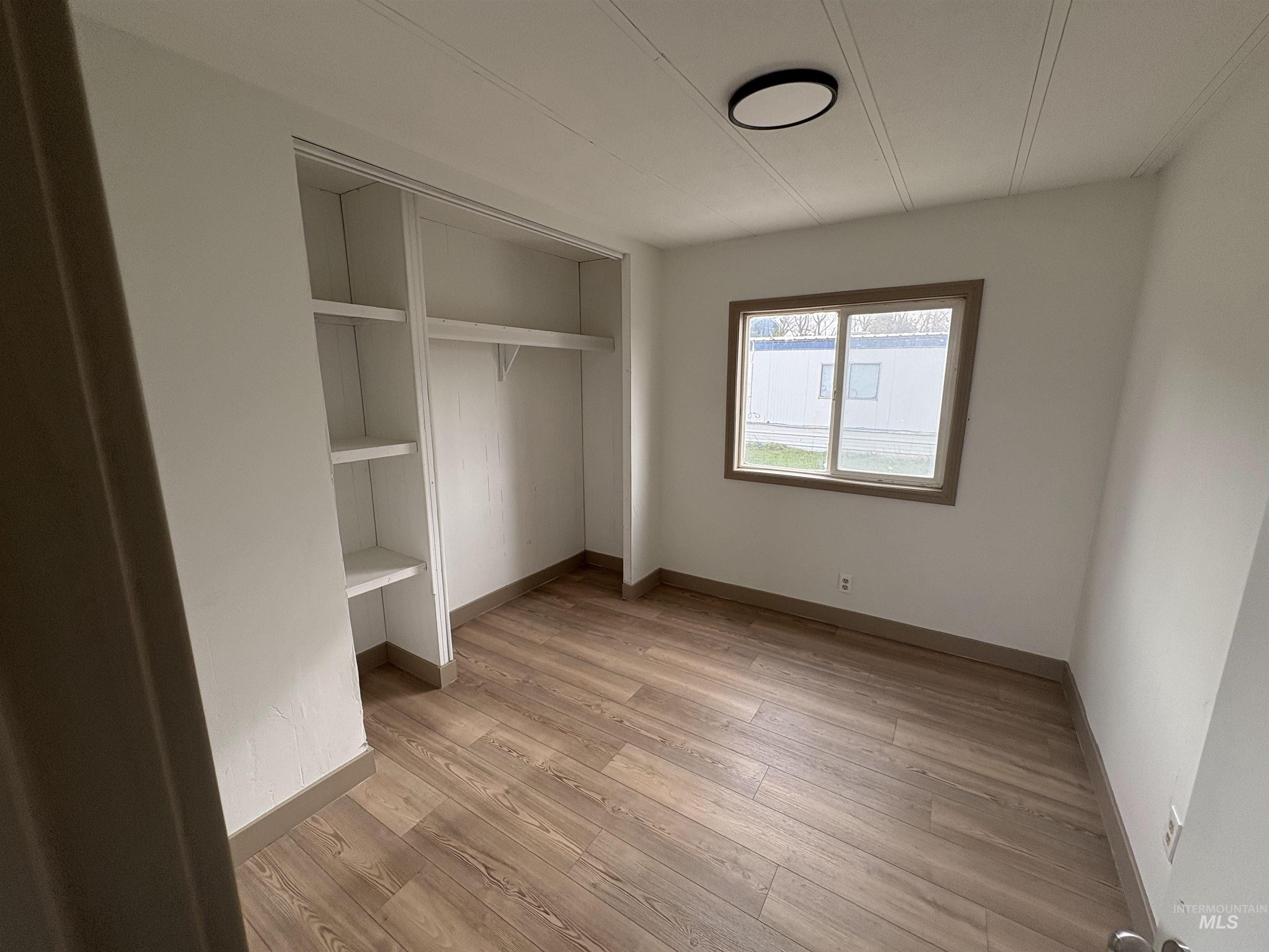 Unfurnished bedroom featuring light wood-type flooring and a closet