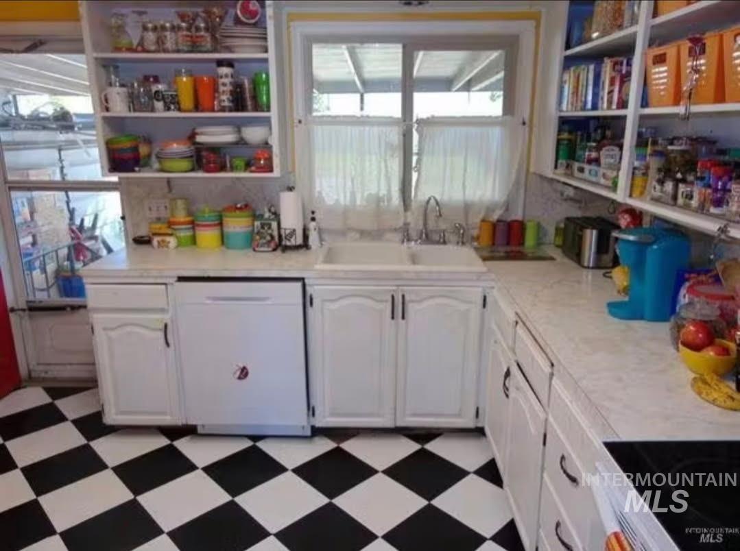 Kitchen with dark floors, white cabinets, dishwasher, black electric range oven, and light countertops