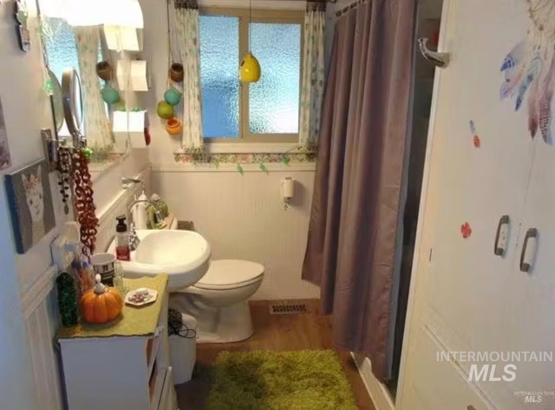 Full bath featuring curtained shower, light wood-style floors, and vanity