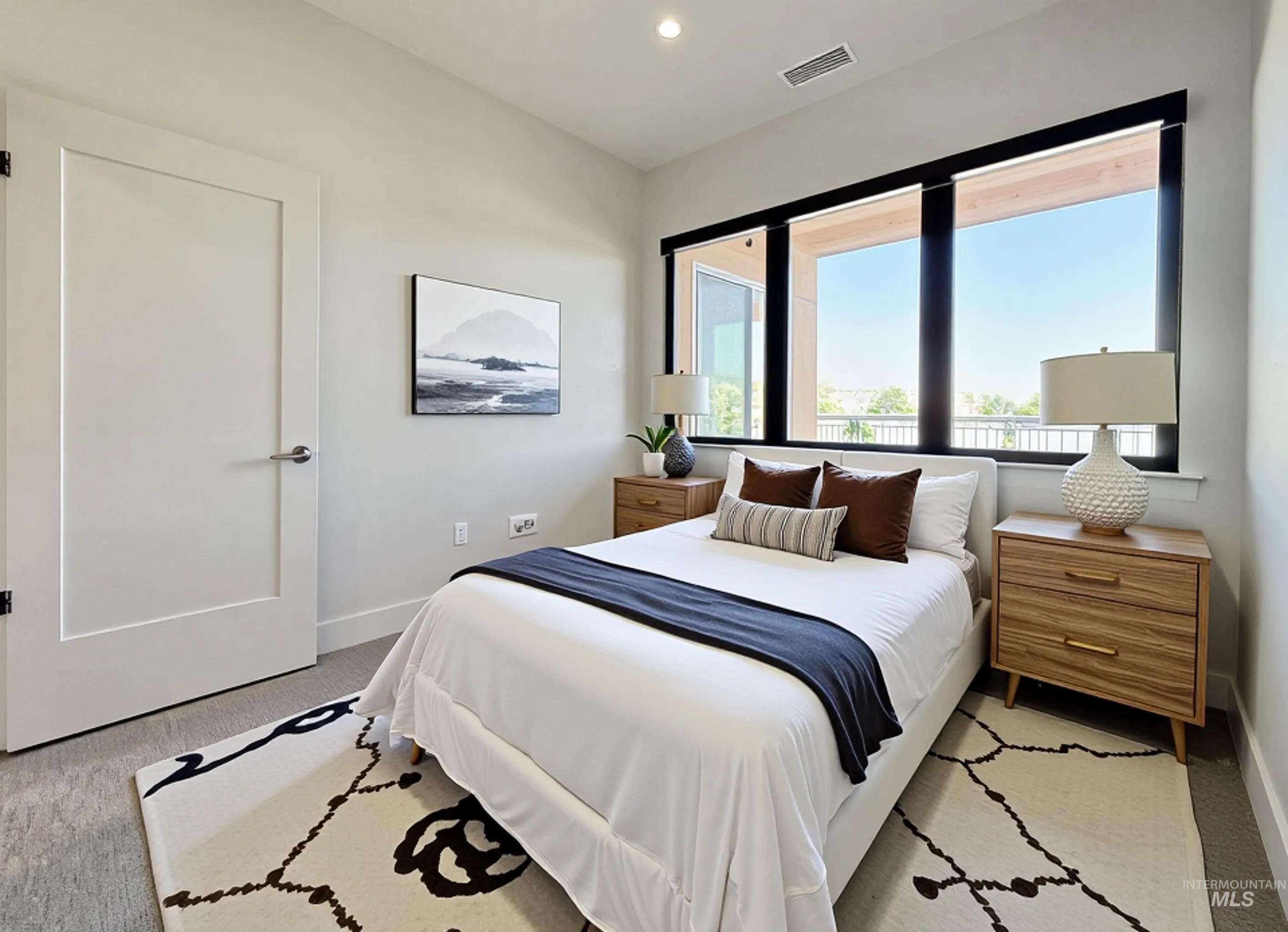 Bedroom with light colored carpet and recessed lighting