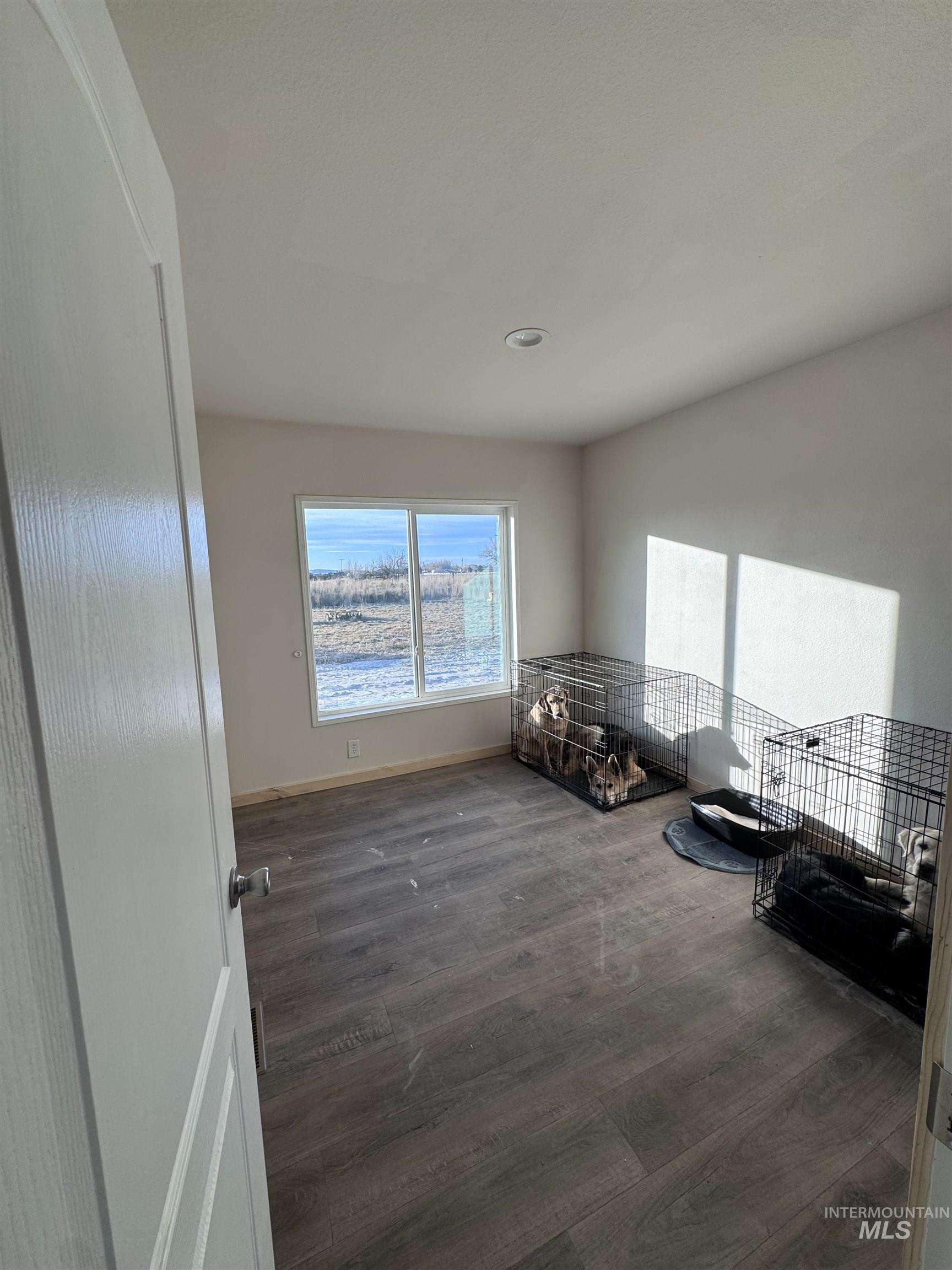 Sitting room featuring dark wood-type flooring and baseboards