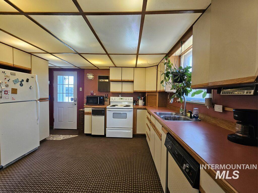 Kitchen featuring white appliances and open shelves