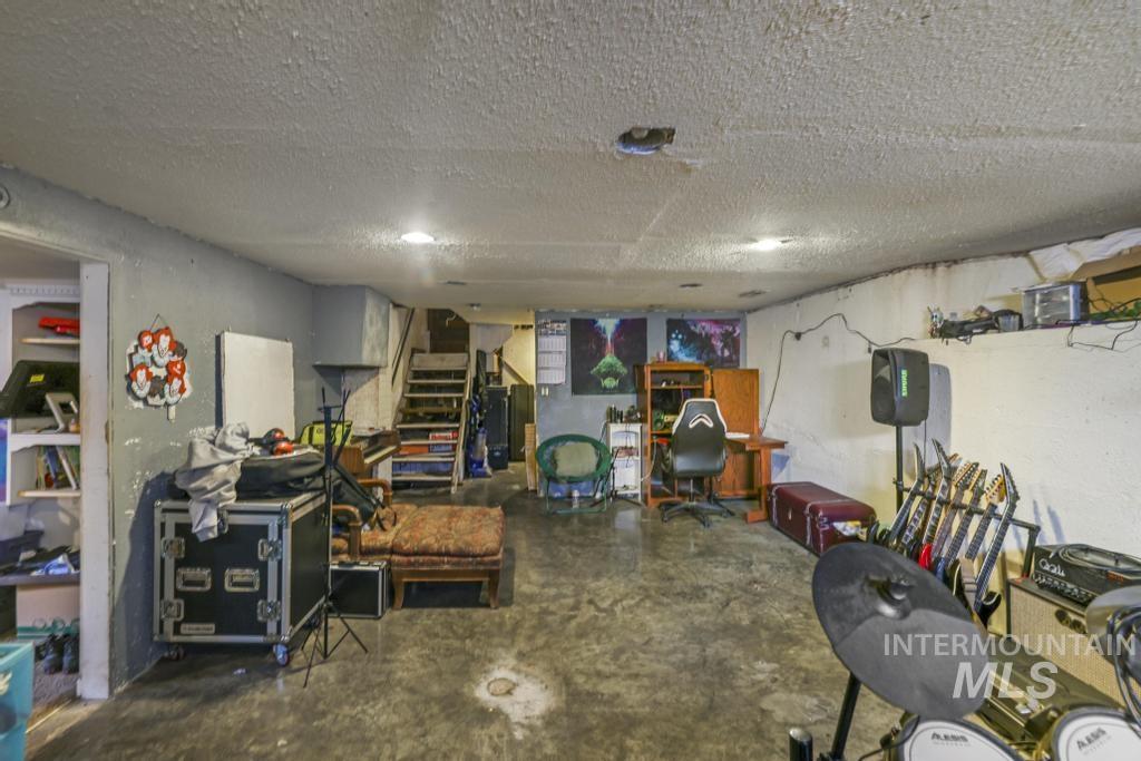 Finished basement featuring stairs and a textured ceiling