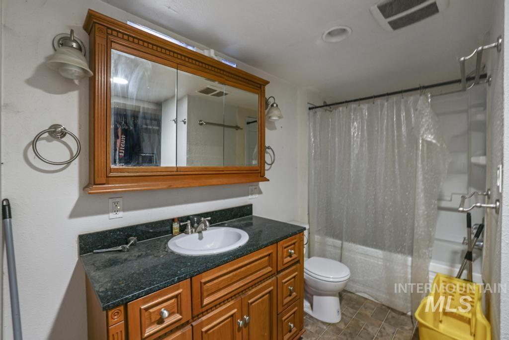 Full bath with shower / bath combo with shower curtain and vanity