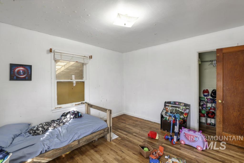 Bedroom featuring wood finished floors and a closet