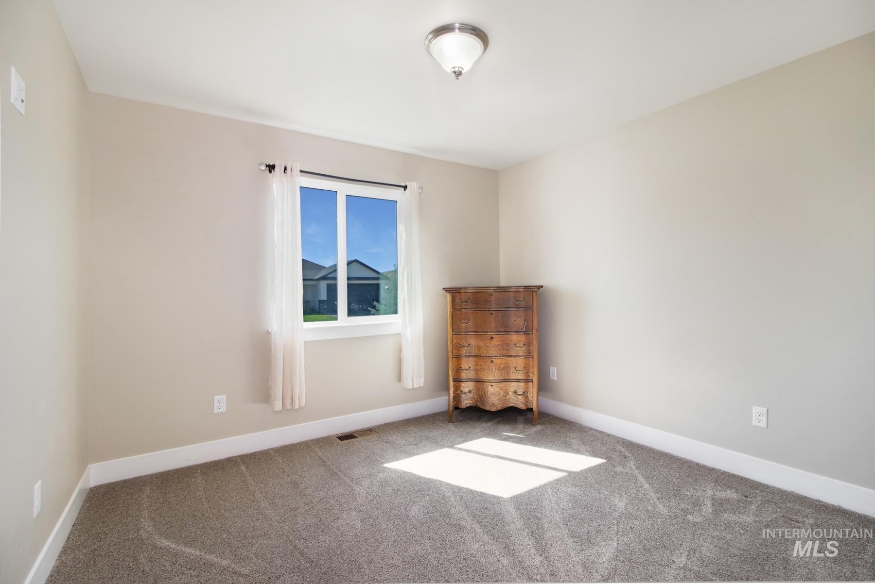 Carpeted empty room with baseboards