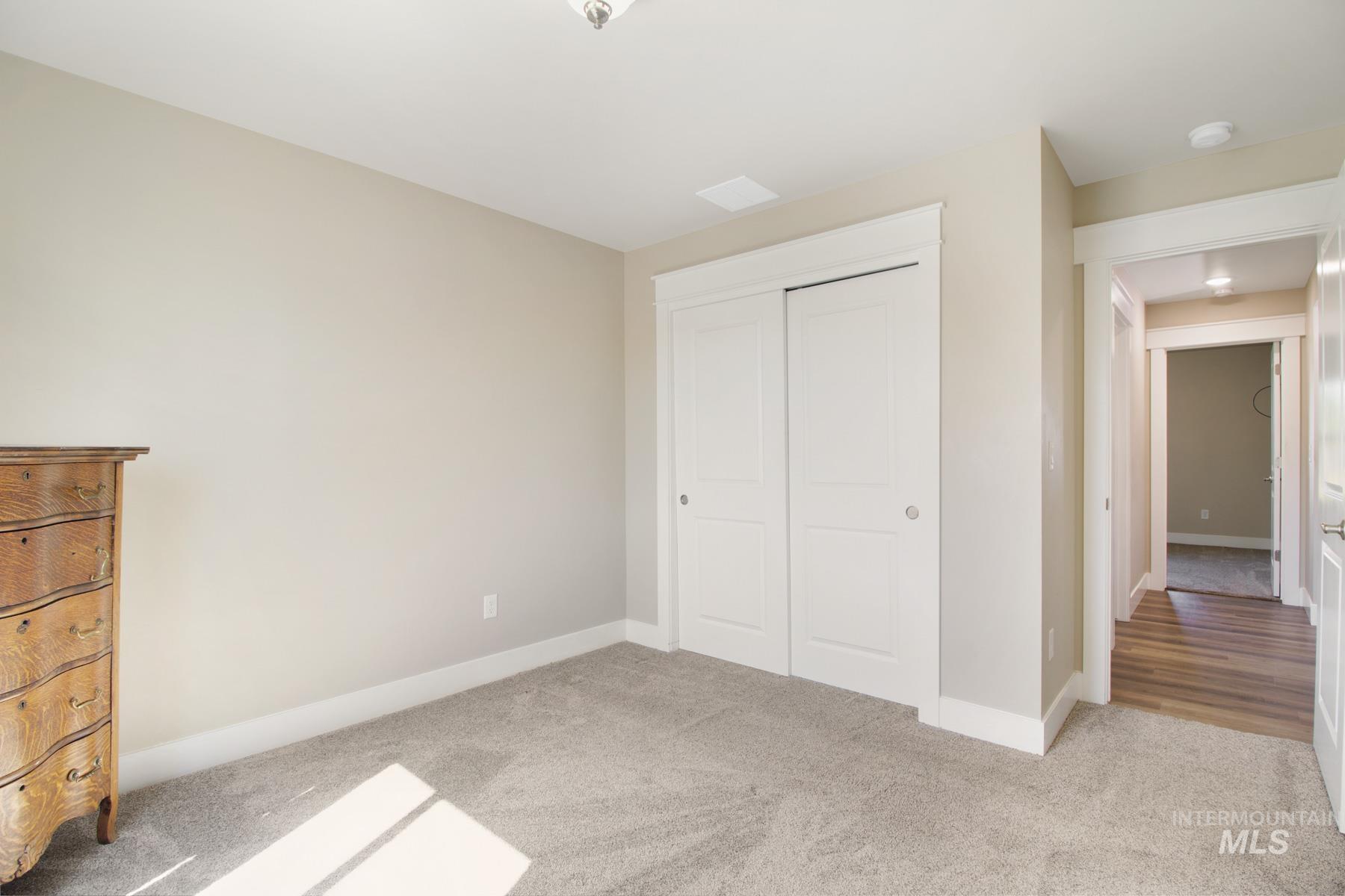 Unfurnished bedroom with light carpet and a closet