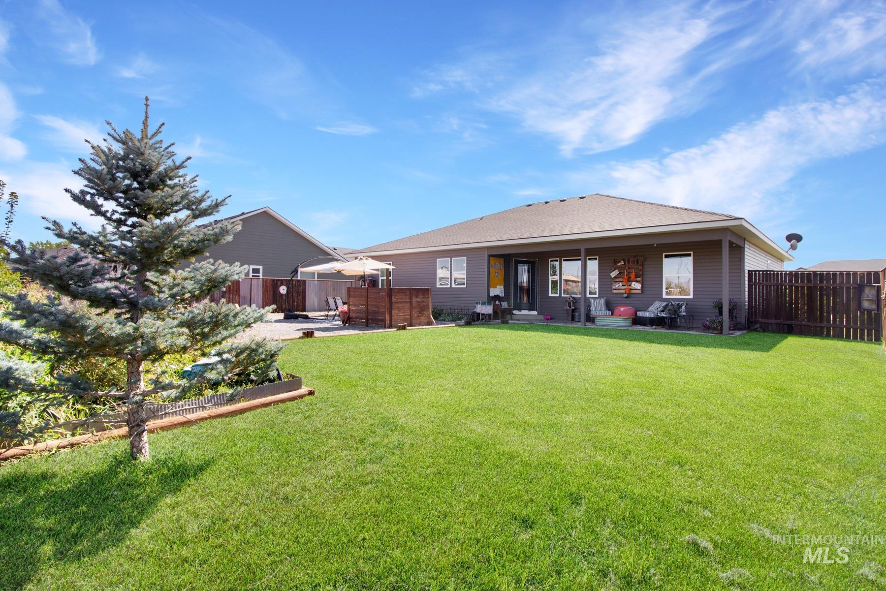 Back of house featuring a patio, a fenced backyard, and a shingled roof