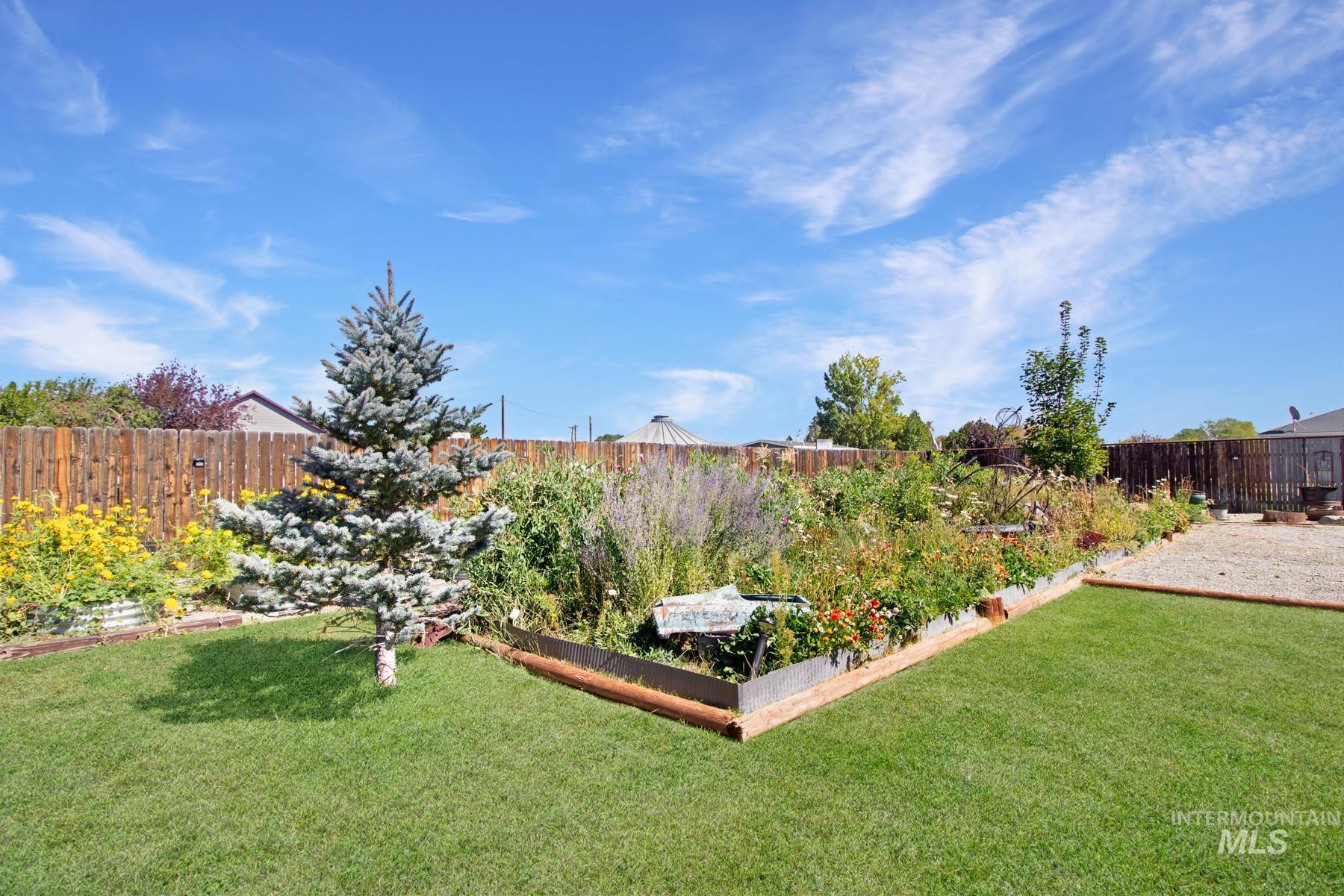 Fenced backyard featuring a vegetable garden