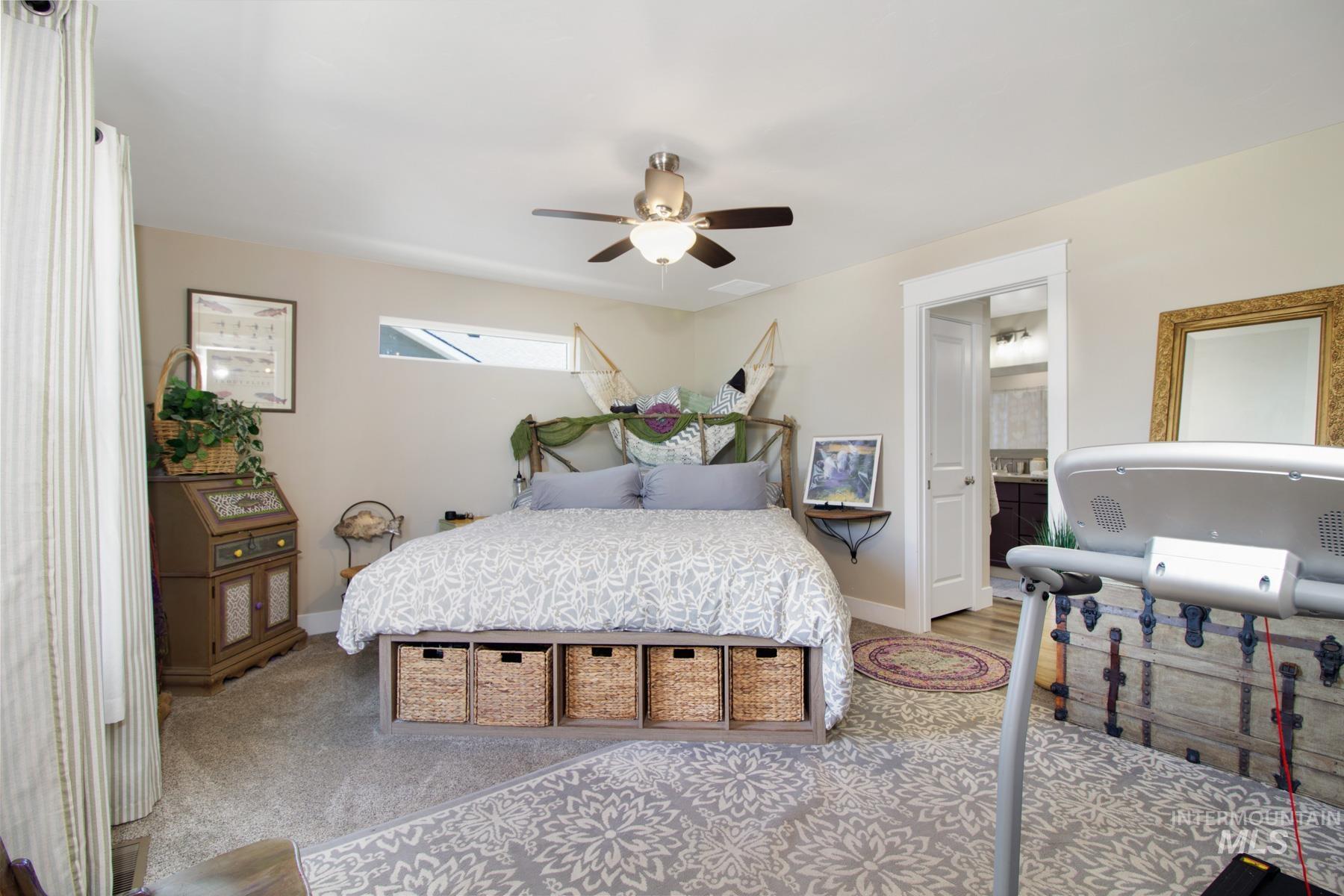 Carpeted bedroom featuring baseboards and a ceiling fan