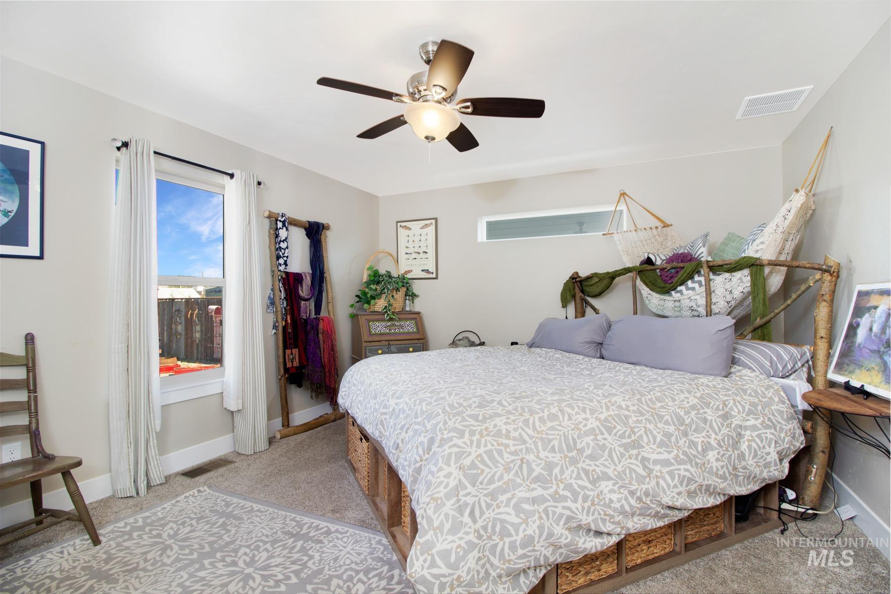 Bedroom with light carpet and ceiling fan