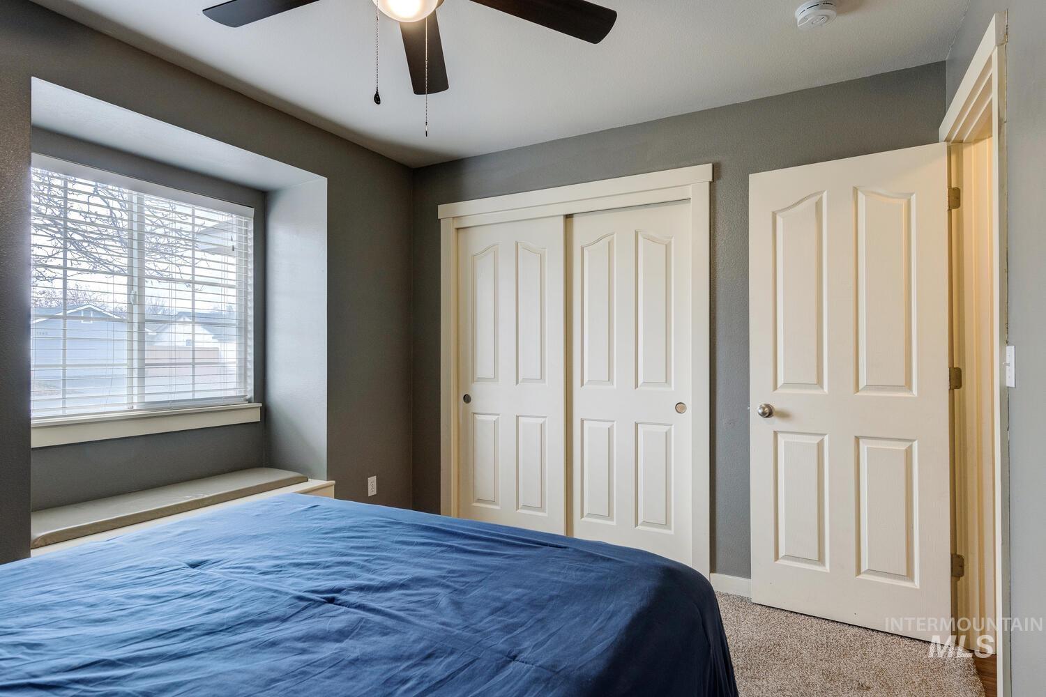 Carpeted bedroom with a closet and ceiling fan