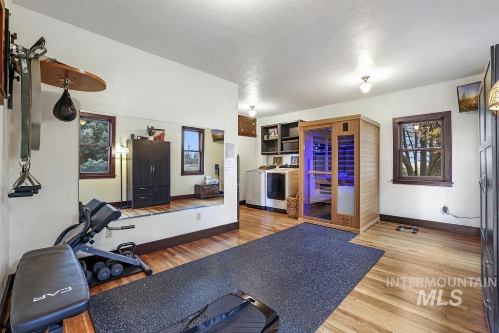 Exercise area with light wood-style floors and washer and clothes dryer