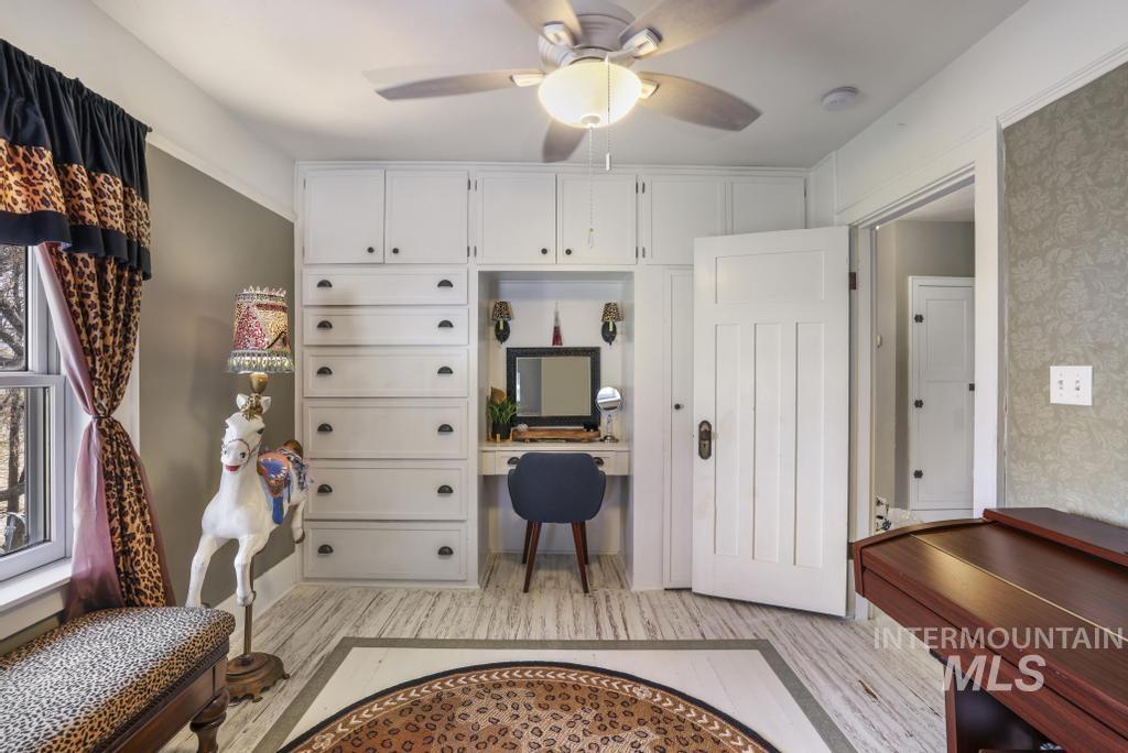 Mudroom featuring a ceiling fan, light wood-style floors, and built in desk