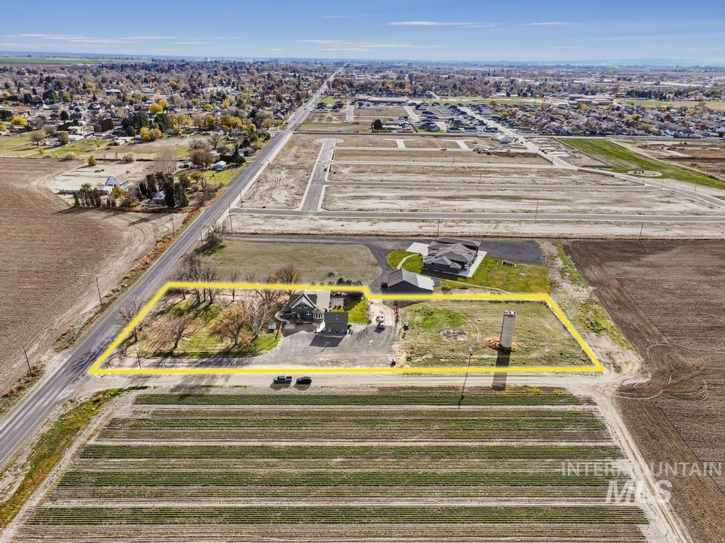Aerial view of sparsely populated area featuring property boundaries highlighted and rows of crops