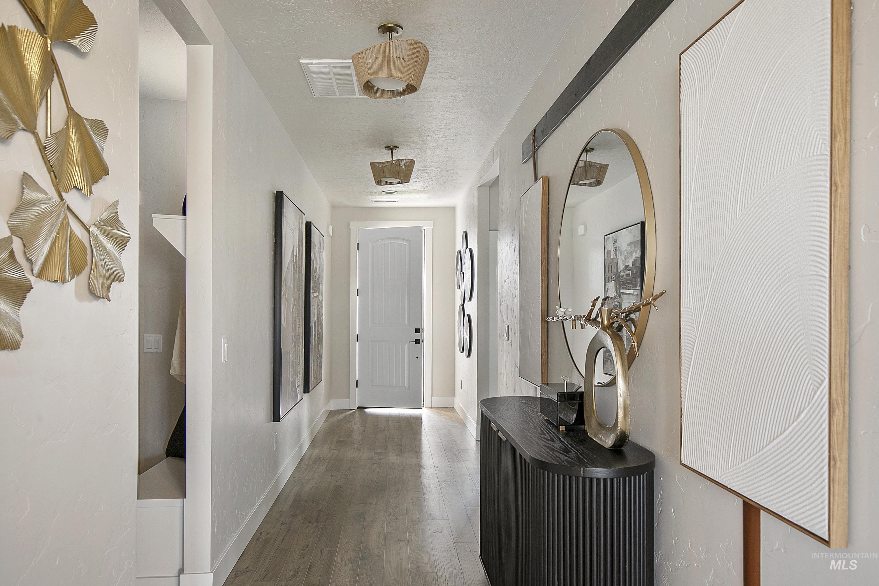 Corridor featuring wood finished floors and a textured ceiling