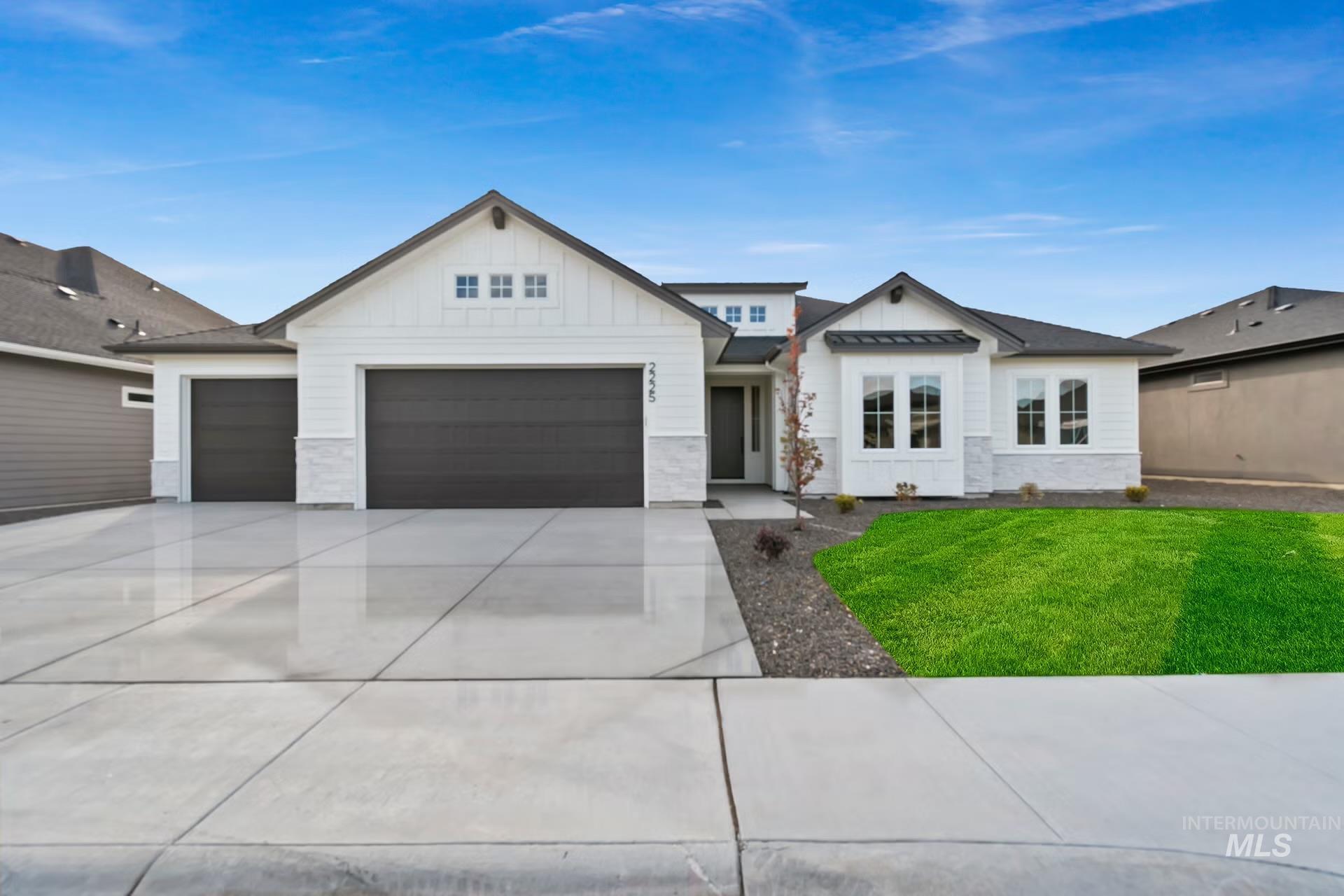 Modern farmhouse style home featuring board and batten siding, concrete driveway, a garage, and a front lawn