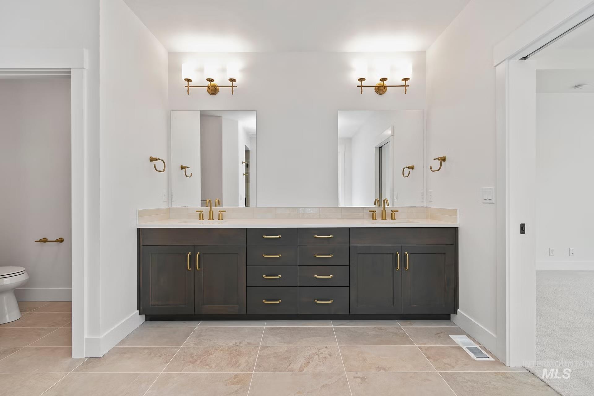 Full bathroom with double vanity and light tile patterned floors