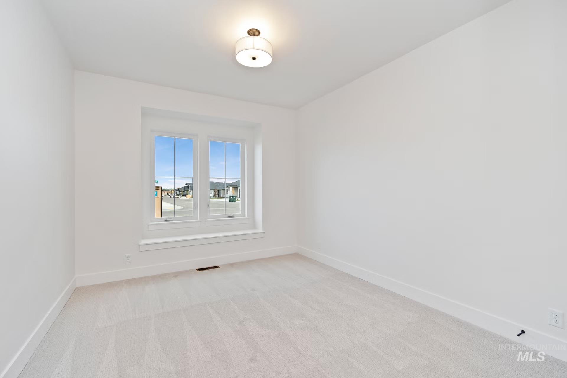 Unfurnished room featuring baseboards and light colored carpet