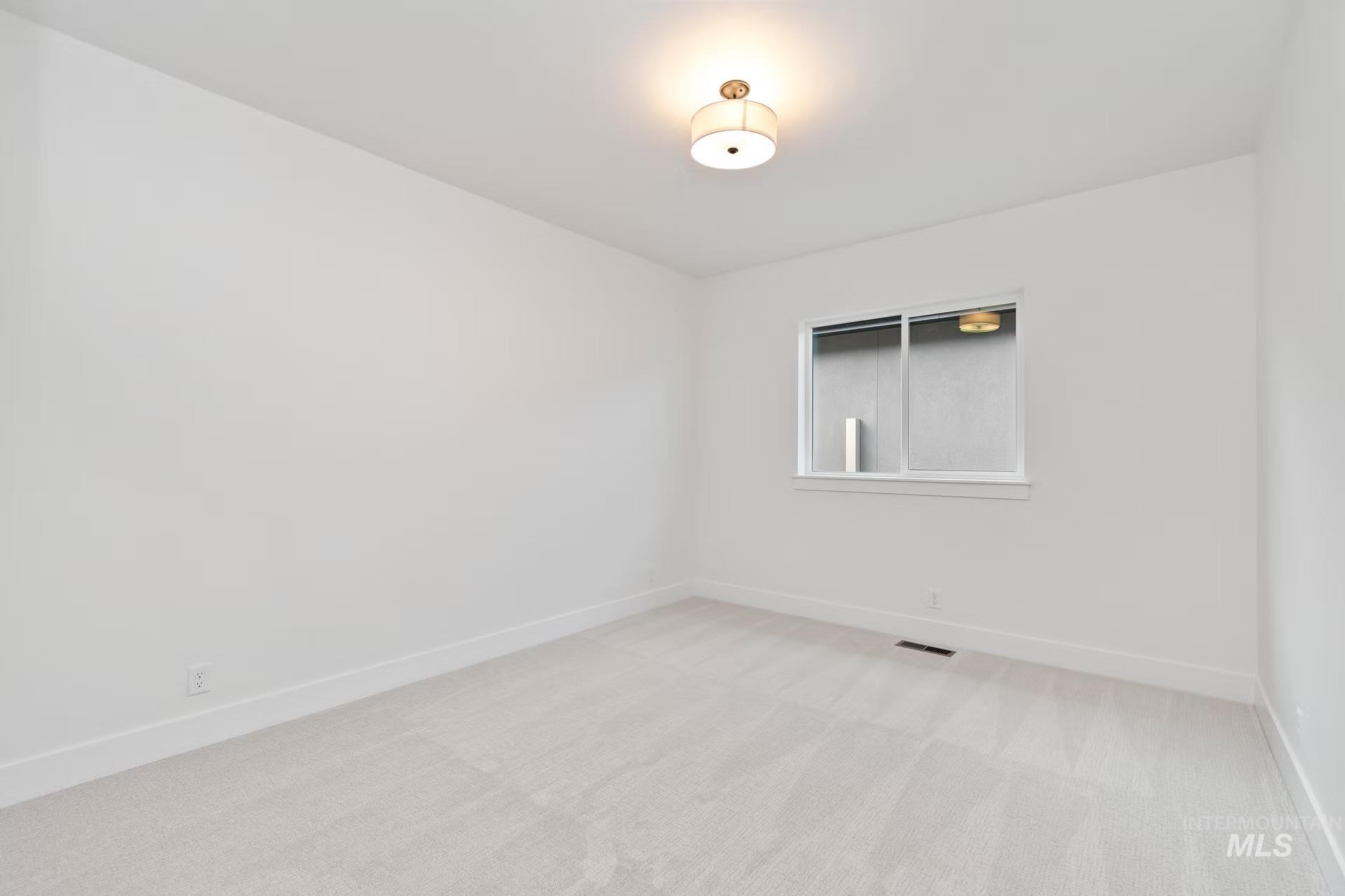 Spare room with baseboards and light carpet