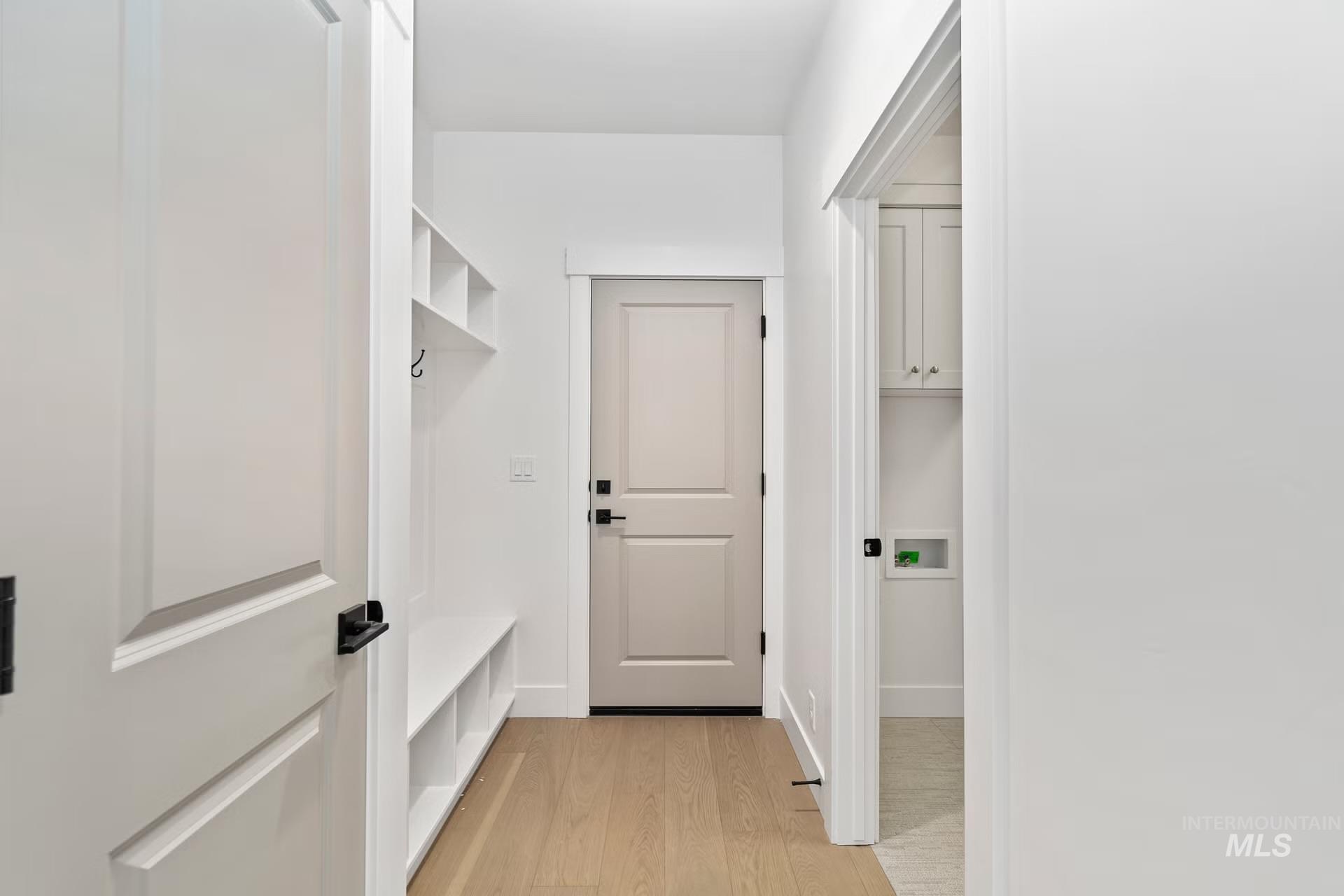 Mudroom featuring light wood-style flooring and baseboards