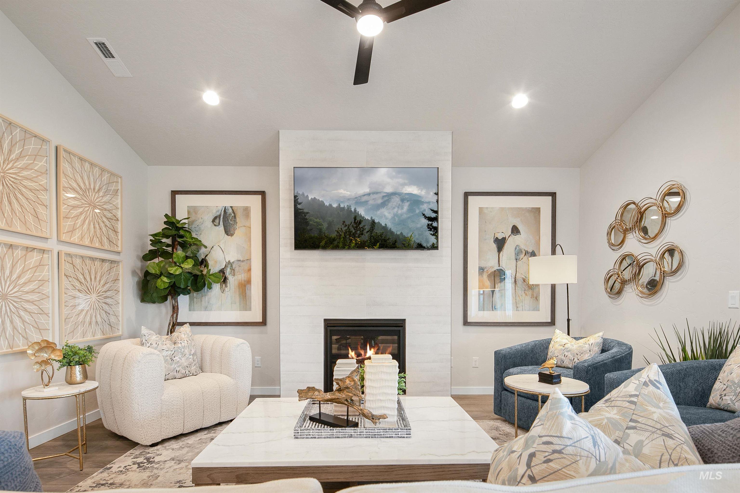 Living room featuring wood finished floors, a tiled fireplace, recessed lighting, and a ceiling fan