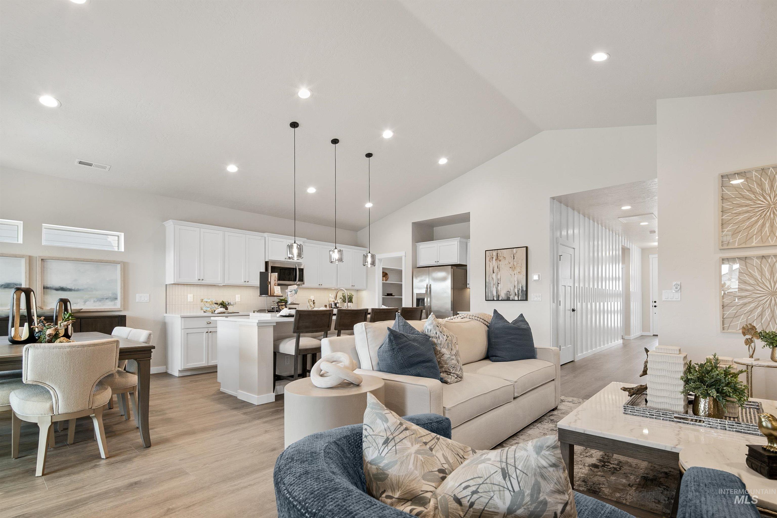 Living area with light wood finished floors, recessed lighting, and high vaulted ceiling