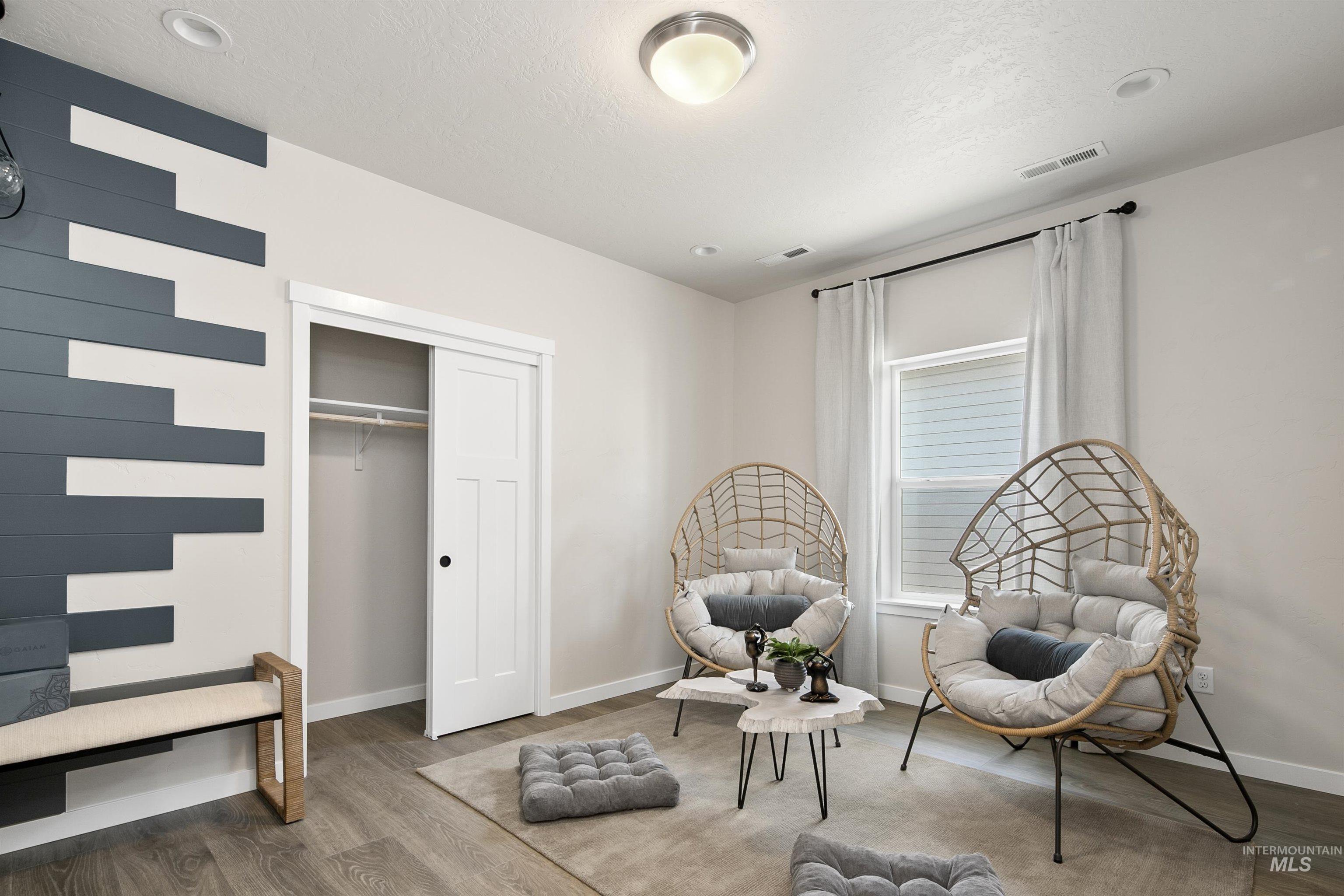 Sitting room with wood finished floors and a textured ceiling
