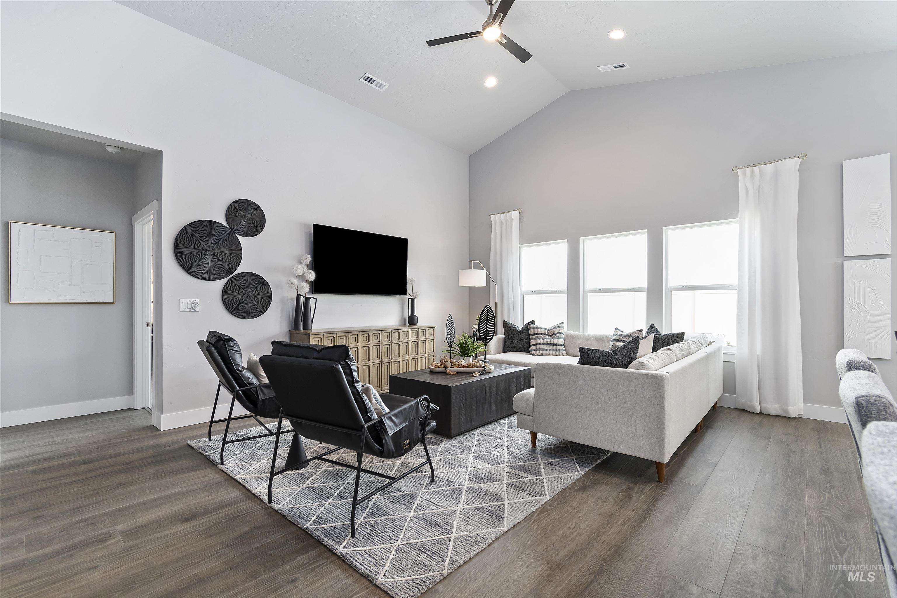 Living area with high vaulted ceiling, dark wood-type flooring, ceiling fan, and recessed lighting