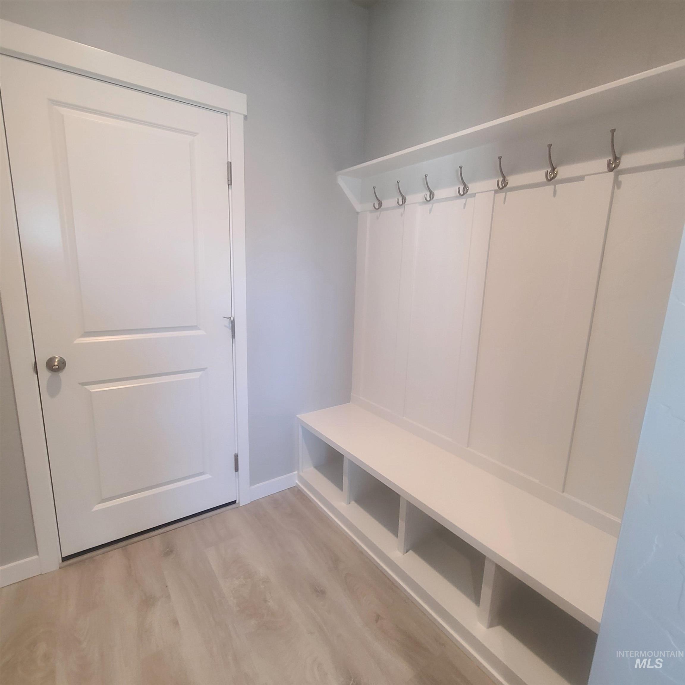 Mudroom with light wood finished floors and baseboards