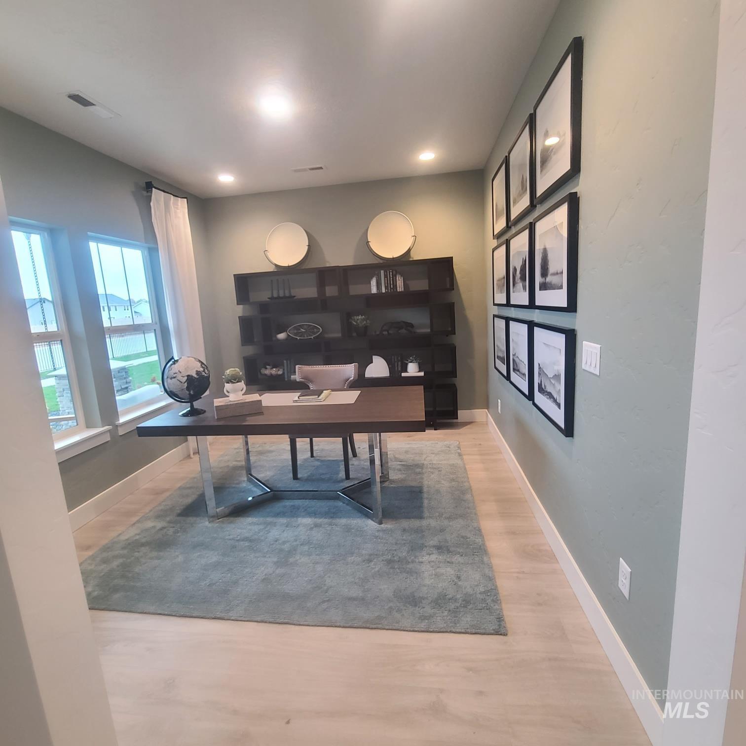 Office space with light wood-style floors and recessed lighting