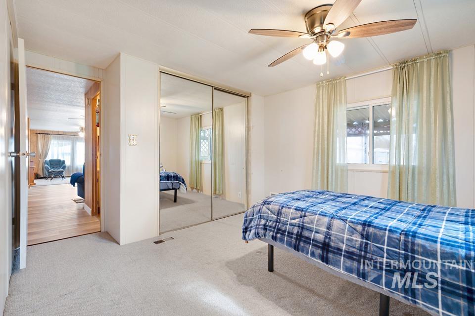Carpeted bedroom featuring a closet and a ceiling fan