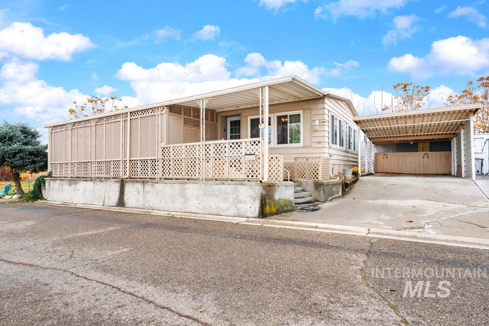 View of front of property featuring driveway and a carport