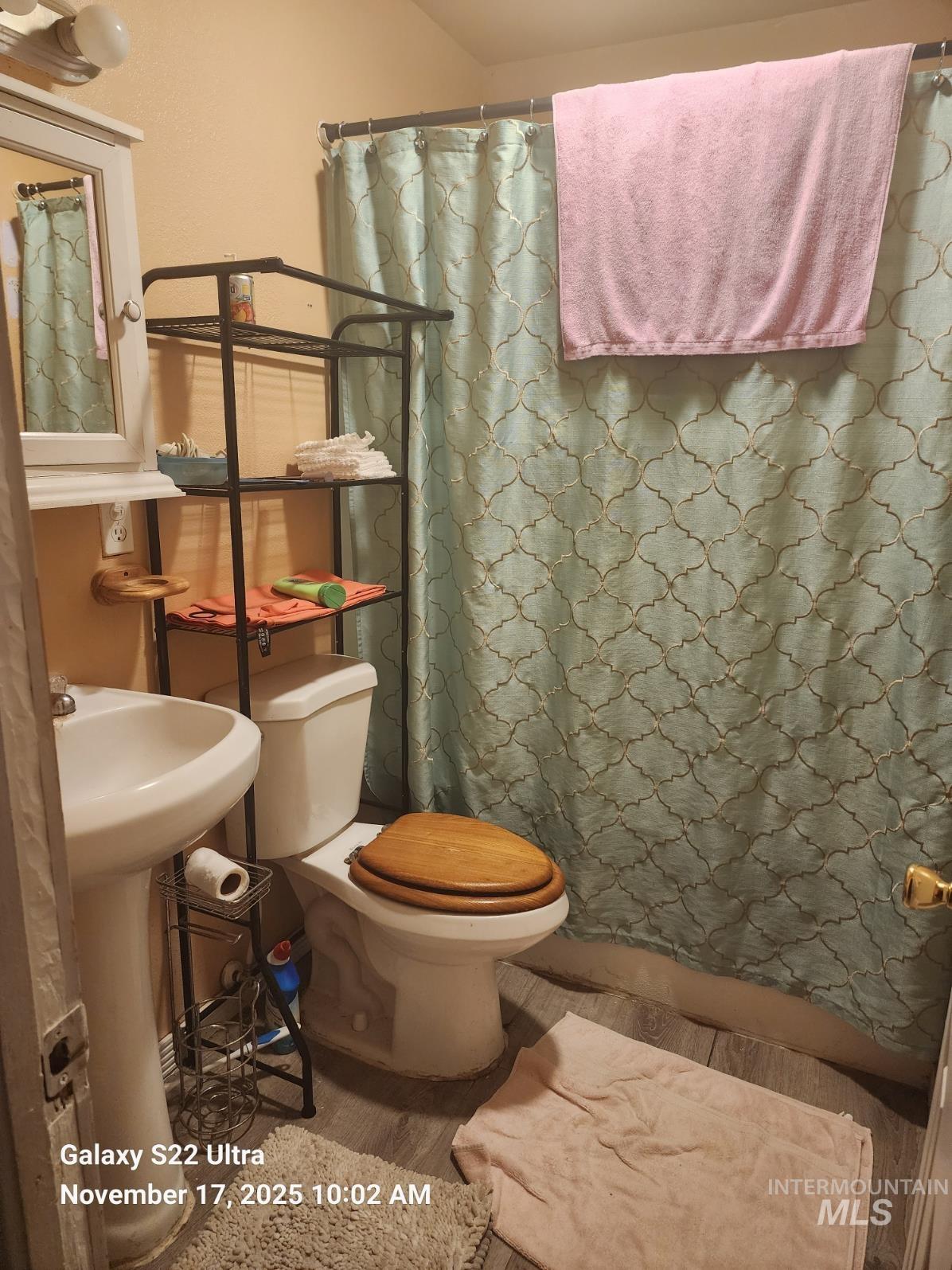 Full bathroom featuring curtained shower and toilet
