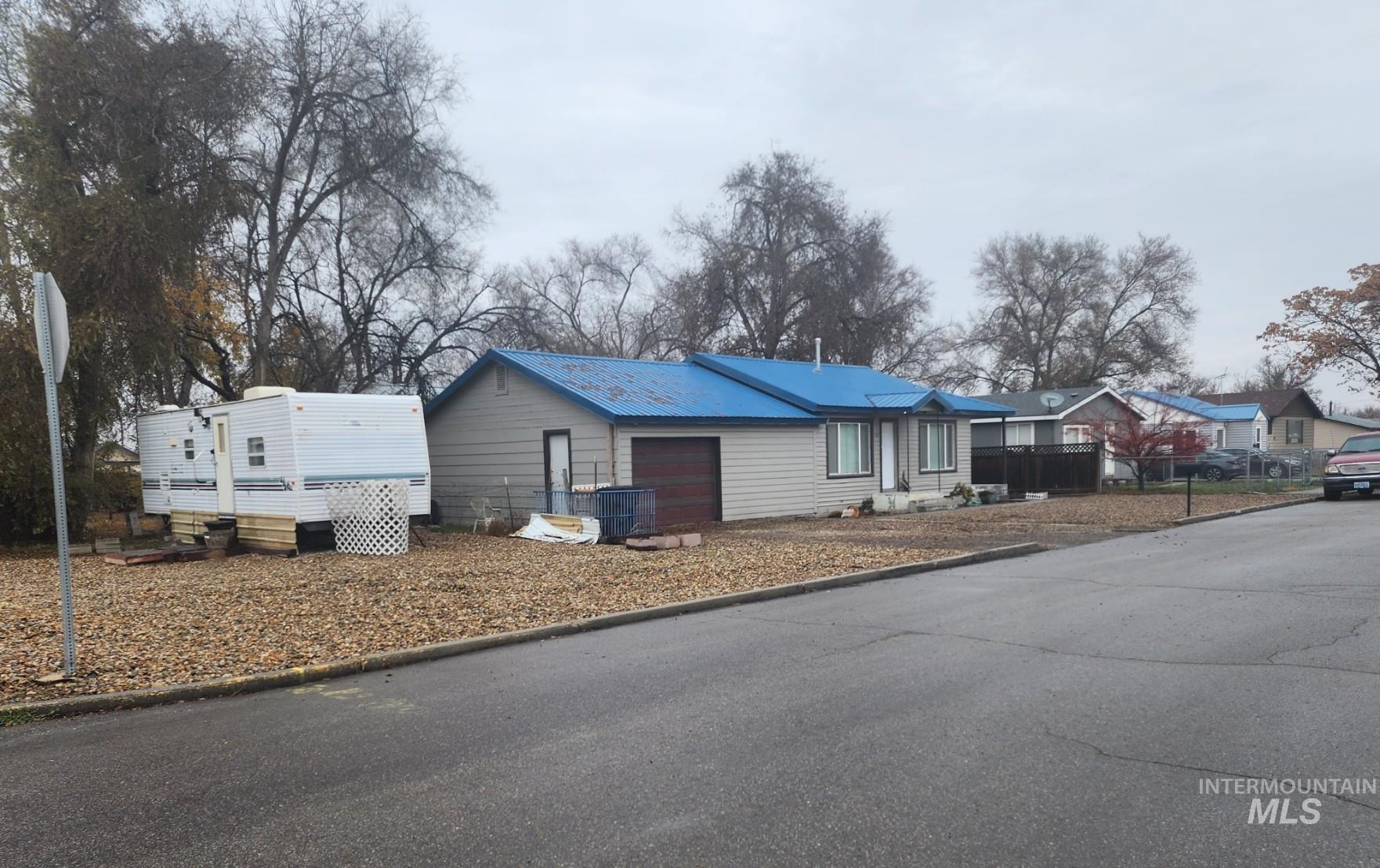 View of home's exterior with a metal roof, a garage, a residential view, and driveway