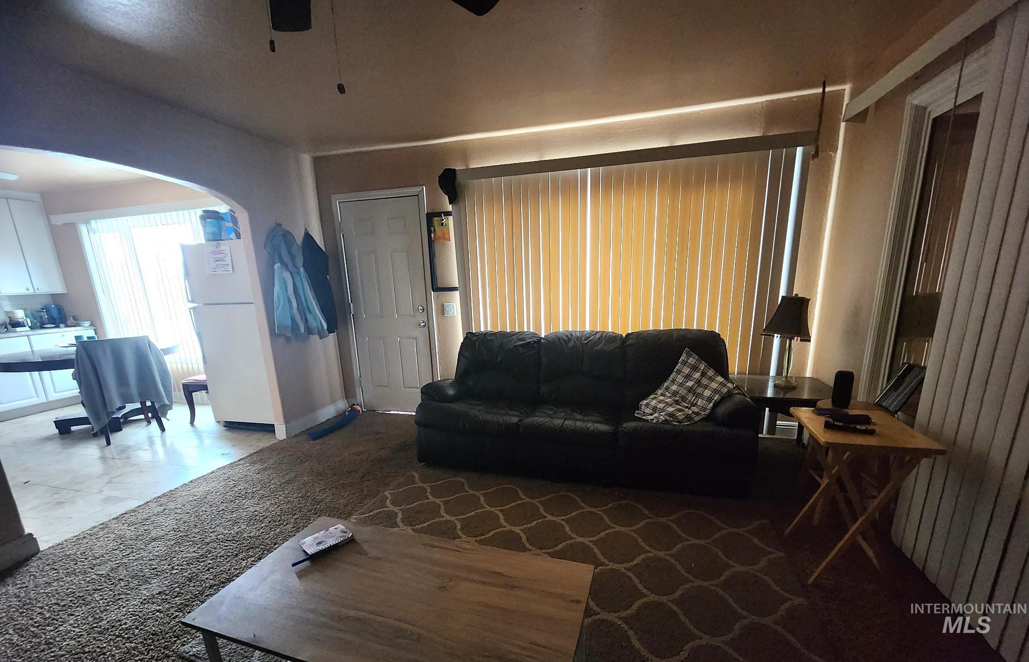 Living room with arched walkways and a ceiling fan