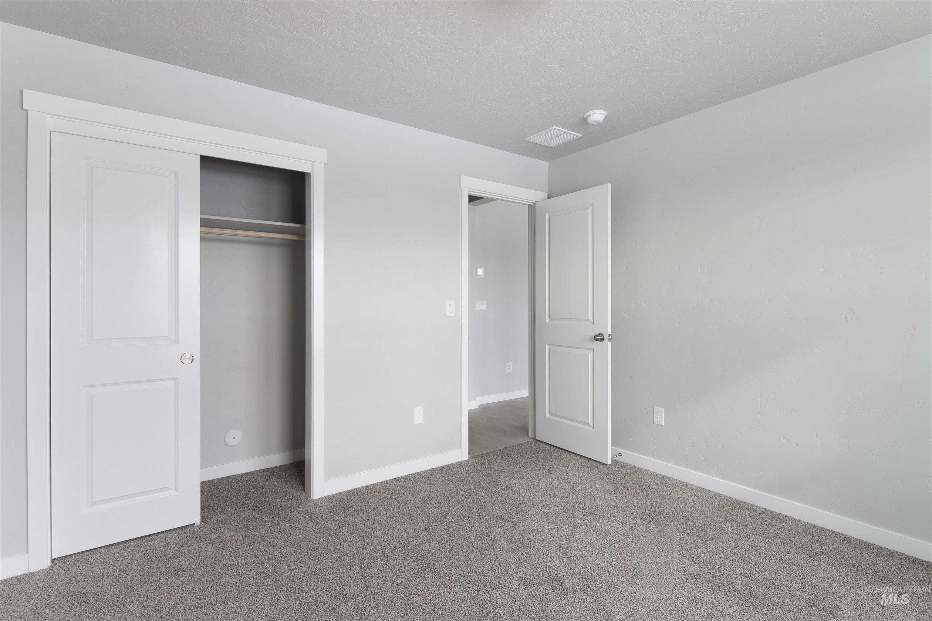 Unfurnished bedroom featuring carpet, a closet, and a textured ceiling