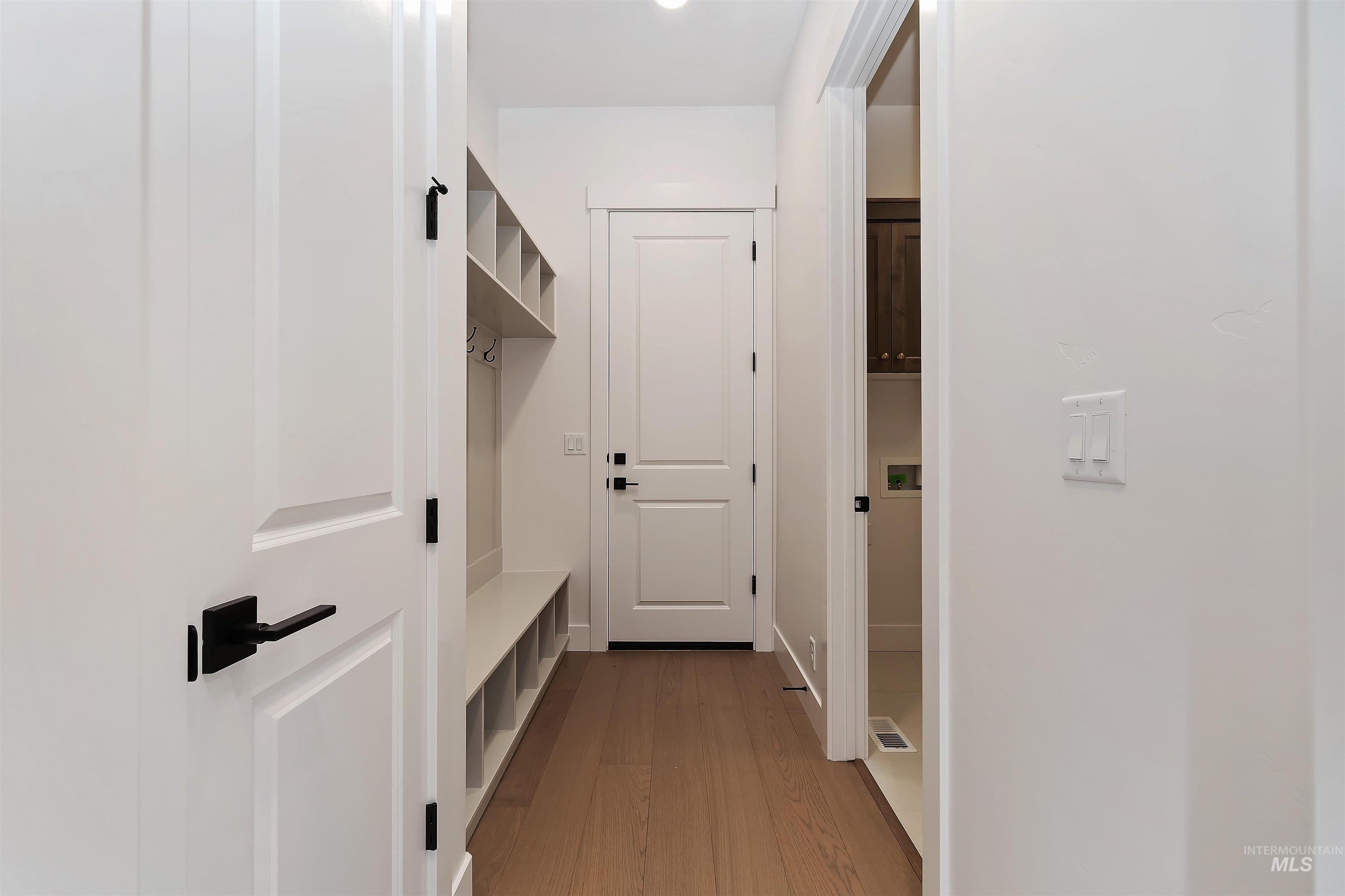 Mudroom with light wood-style flooring and baseboards