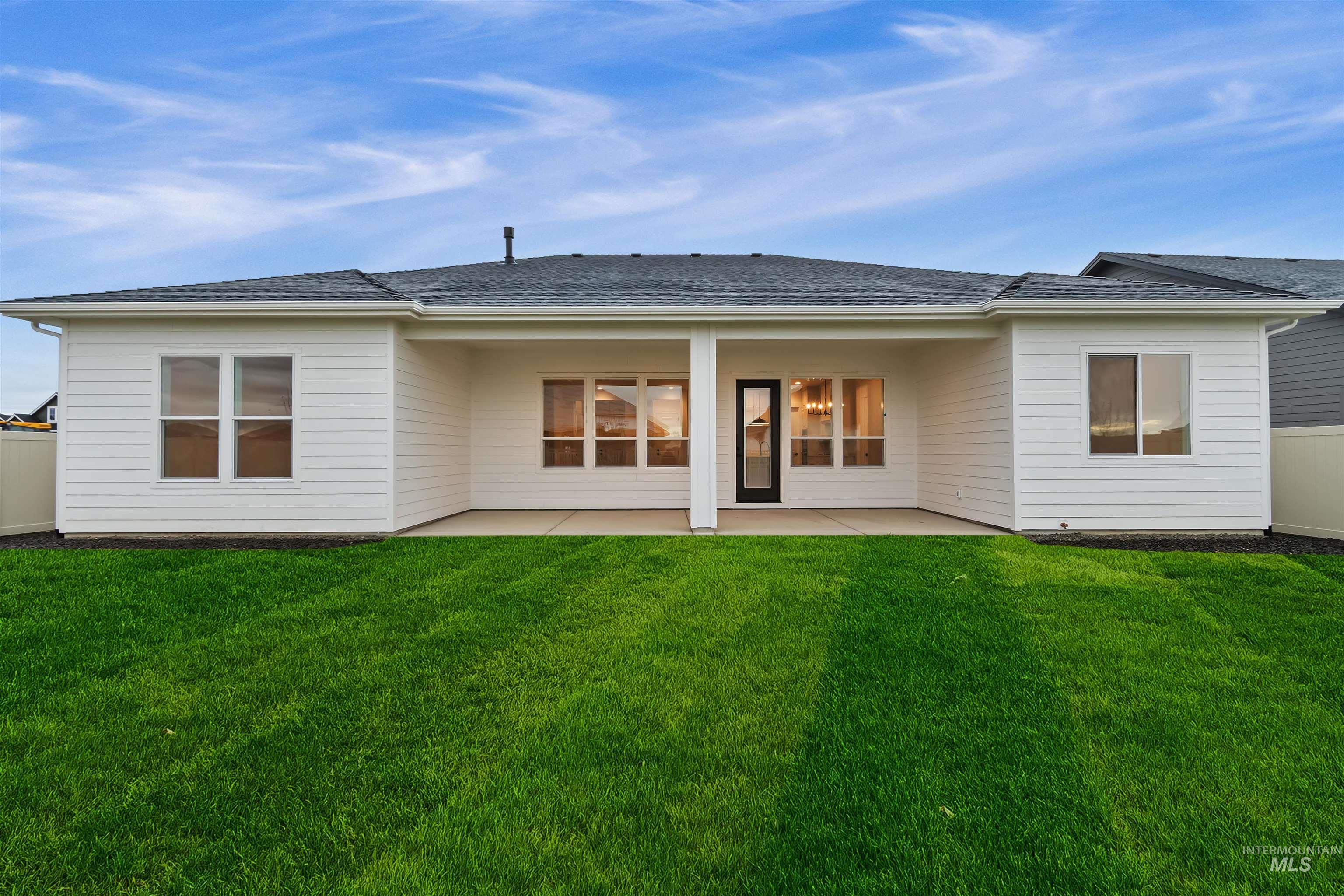 Back of house with a patio area and a shingled roof