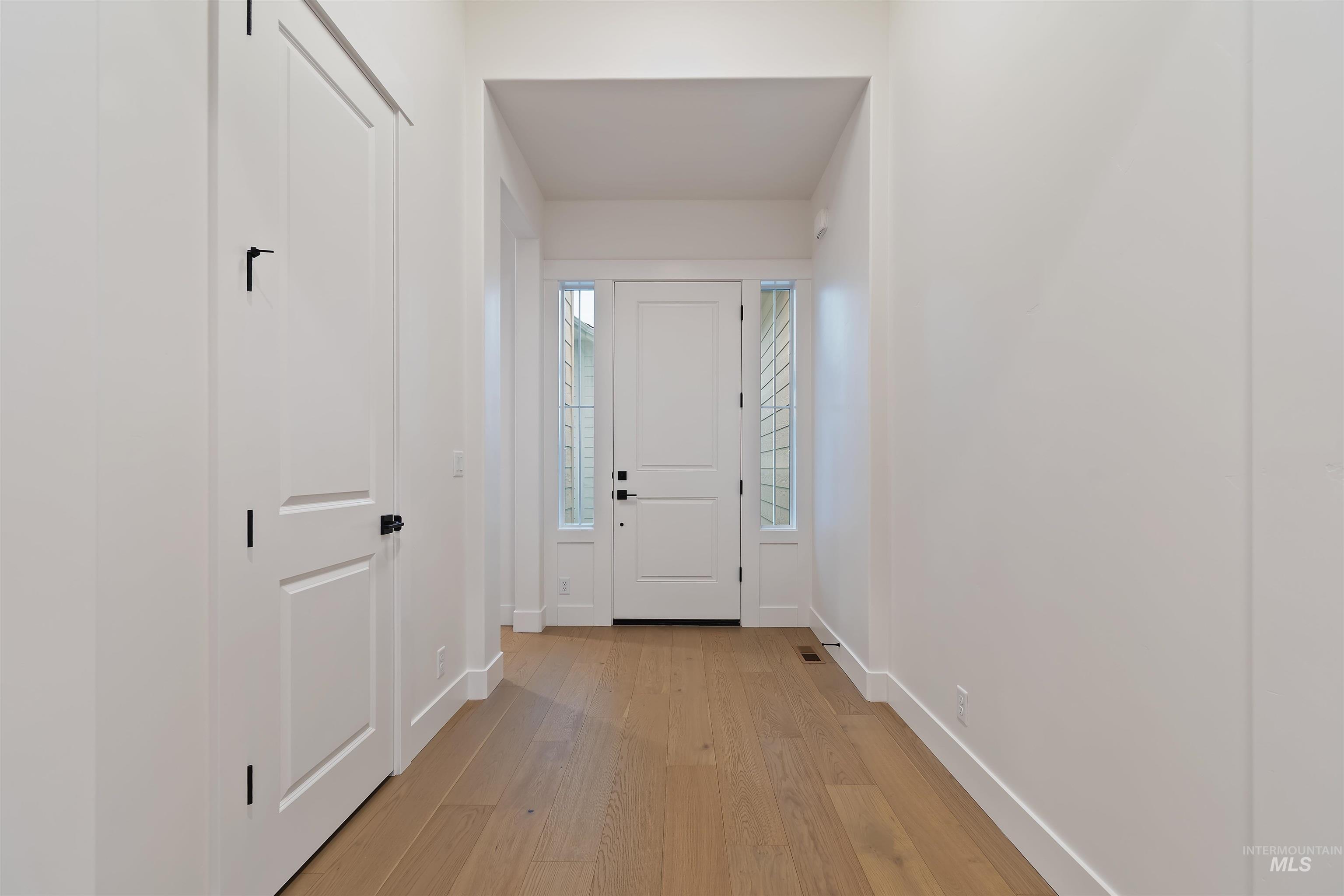 Foyer featuring light wood-style floors and baseboards
