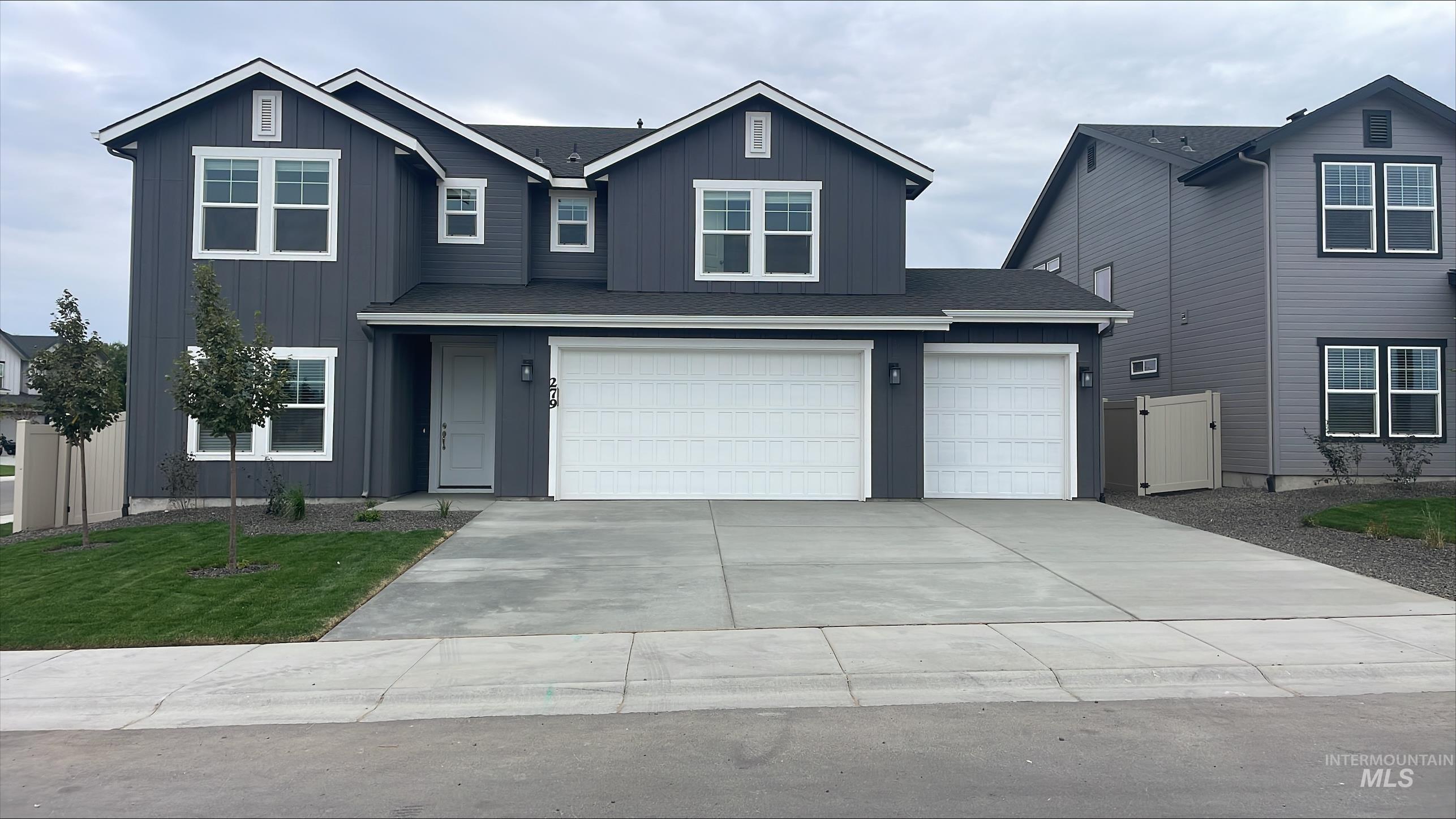 View of front of home featuring board and batten siding, driveway, and a garage