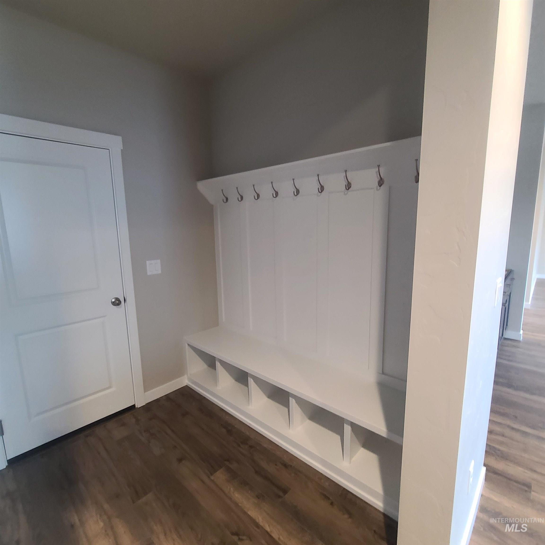 Mudroom with dark wood-type flooring and baseboards